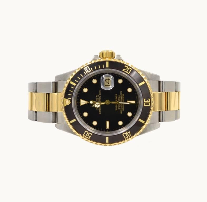 A Rolex Submariner wristwatch reference 16803. If you're looking for a classic Submariner you found it. This 18 karat yellow gold and steel watch features a black original dial, Oyster 18 karat two-tone bracelet, sapphire crystal, gold waterproof