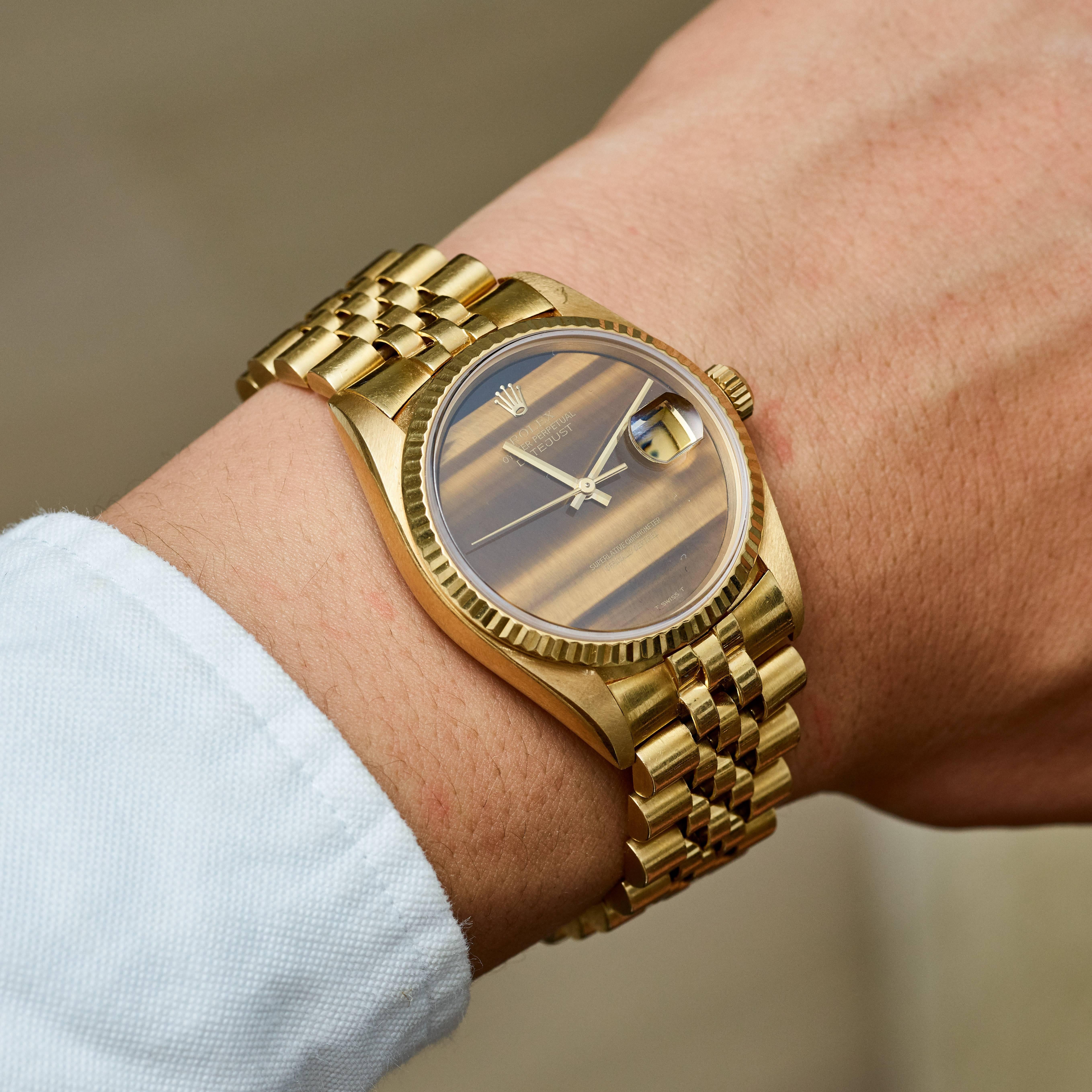 Rolex 18K Yellow Gold Oyster Perpetual Datejust Wristwatch
Factory Rolex Tiger's Eye Quartz Hard Stone Dial
Stunning Original Rolex Tiger's Eye Dial without Numerals 
Matching Hands to Dial 
18K Yellow Gold Fluted Bezel
36mm in size 
Rolex Calibre