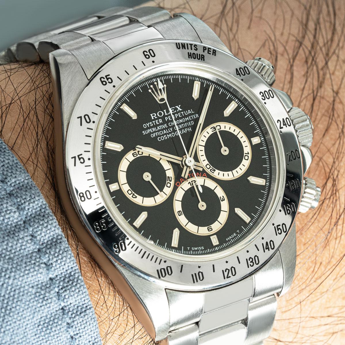 Eine Zenith Daytona von Rolex aus Edelstahl. Die Uhr verfügt über ein schwarzes Zifferblatt, eine eingravierte tachymetrische Skala, drei Chronographenzähler und Drücker; Merkmale, die die Daytona zum ultimativen Zeitmessinstrument für