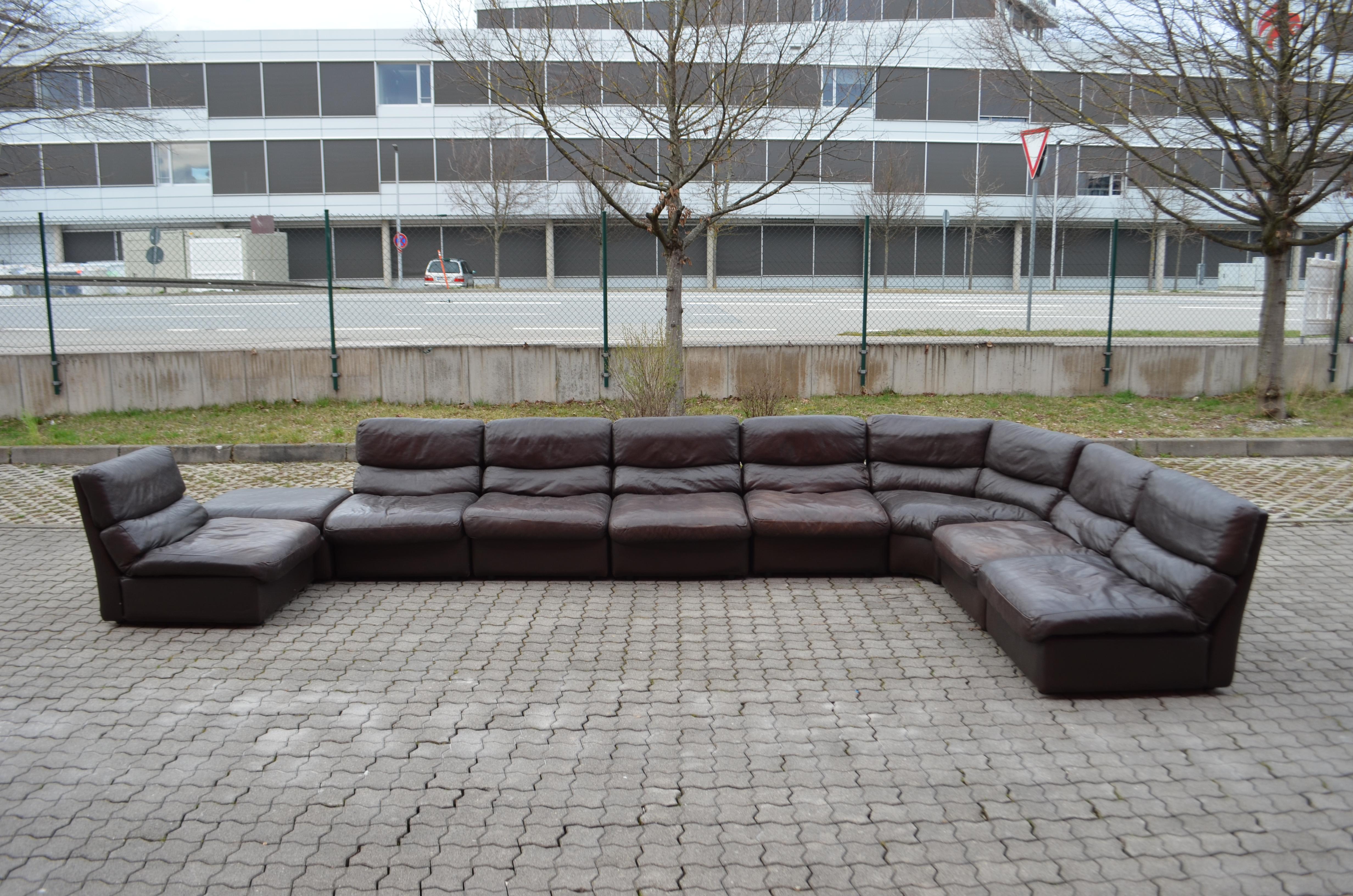 This stunning Modular sectional leather sofa was produced by Rolf Benz manufactured in Germany.
It is a pure 70ties design with timeless modern shape.
The leather is a aniline brown color with a soft leather touch.
The pillows are filled with down