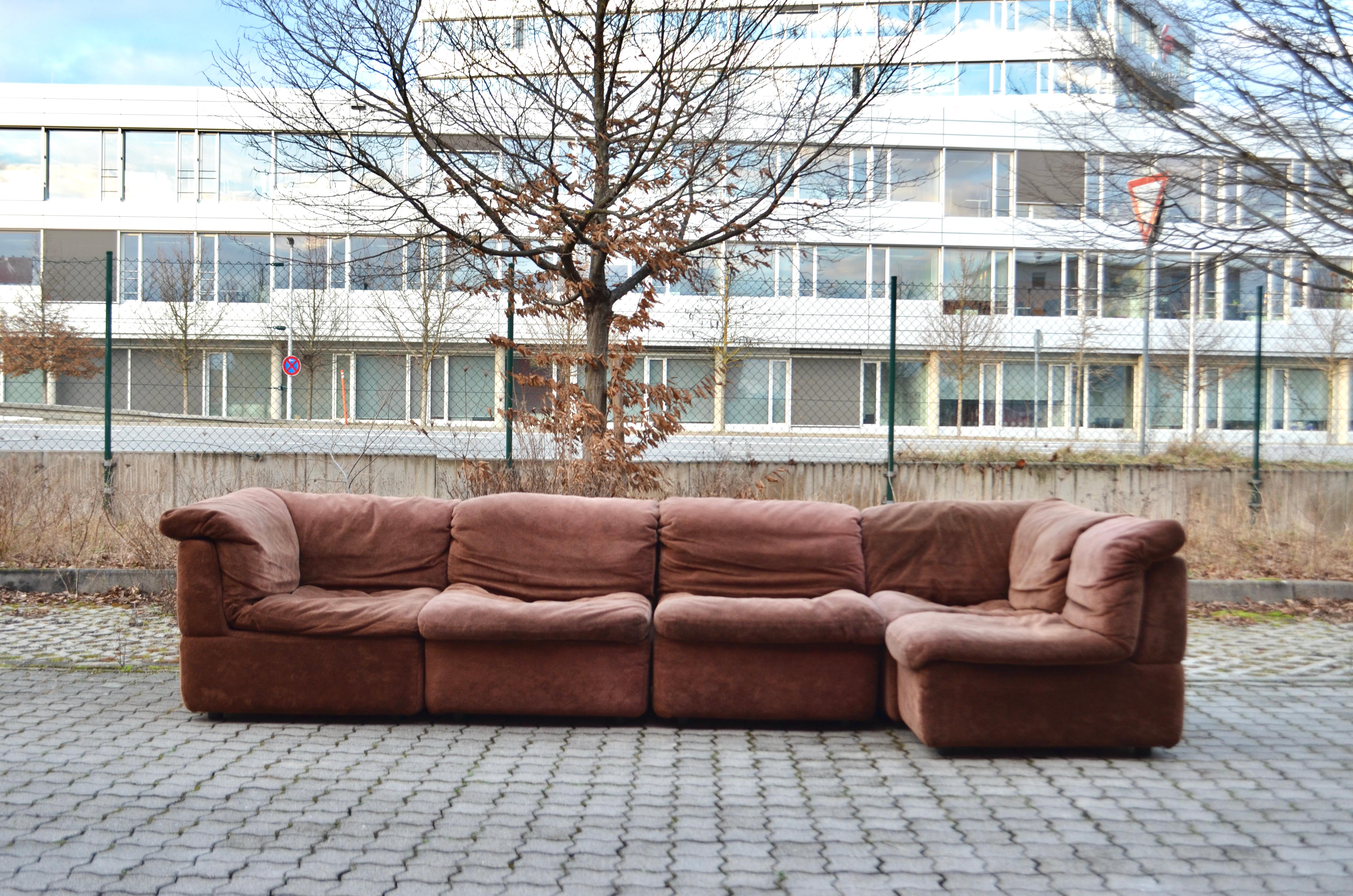 This Modular sectional sofa was designed by Rolf Benz and manufactured in Germany.
It is a pure 70ties design with timeless modern shape.
The fabric is Velours and has a brown color with a soft touch.
The frame of every element is made of hardfoam/