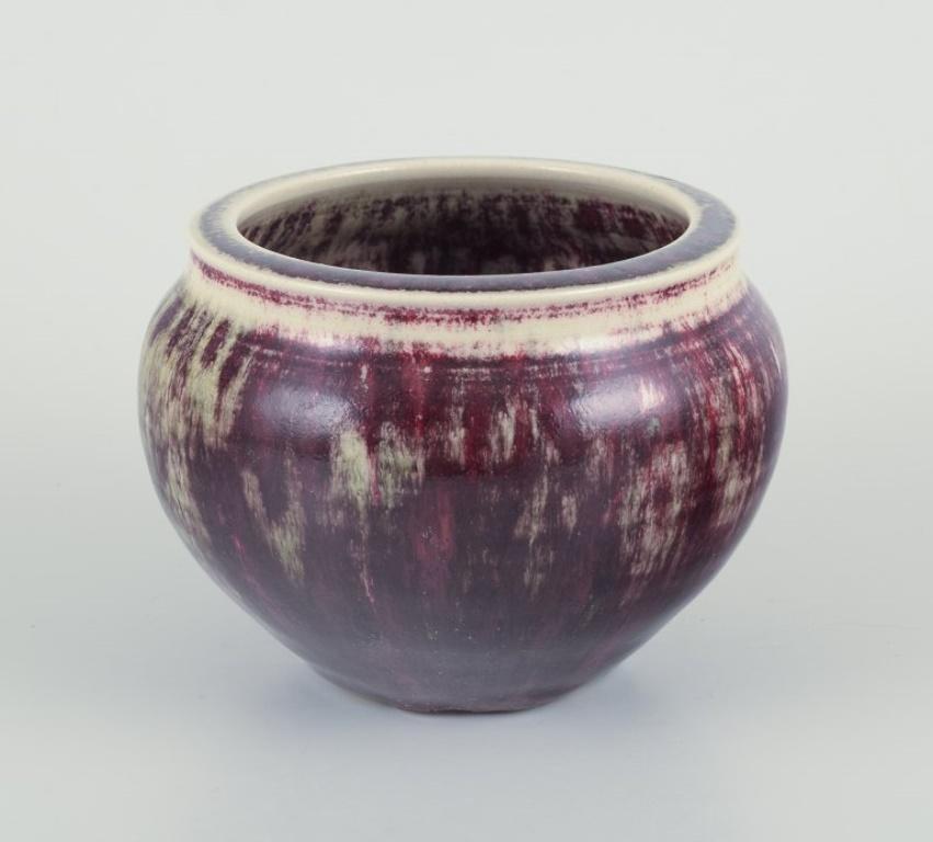 Rolf Fagerberg (1934-2008).
Swedish ceramicist. Unique ceramic jar.
Glaze in violet and sand colored tones.
Late 20th century.
Signed.
Perfect condition.
Dimensions: Diameter 12.0 cm. x Height 9.5 cm.
