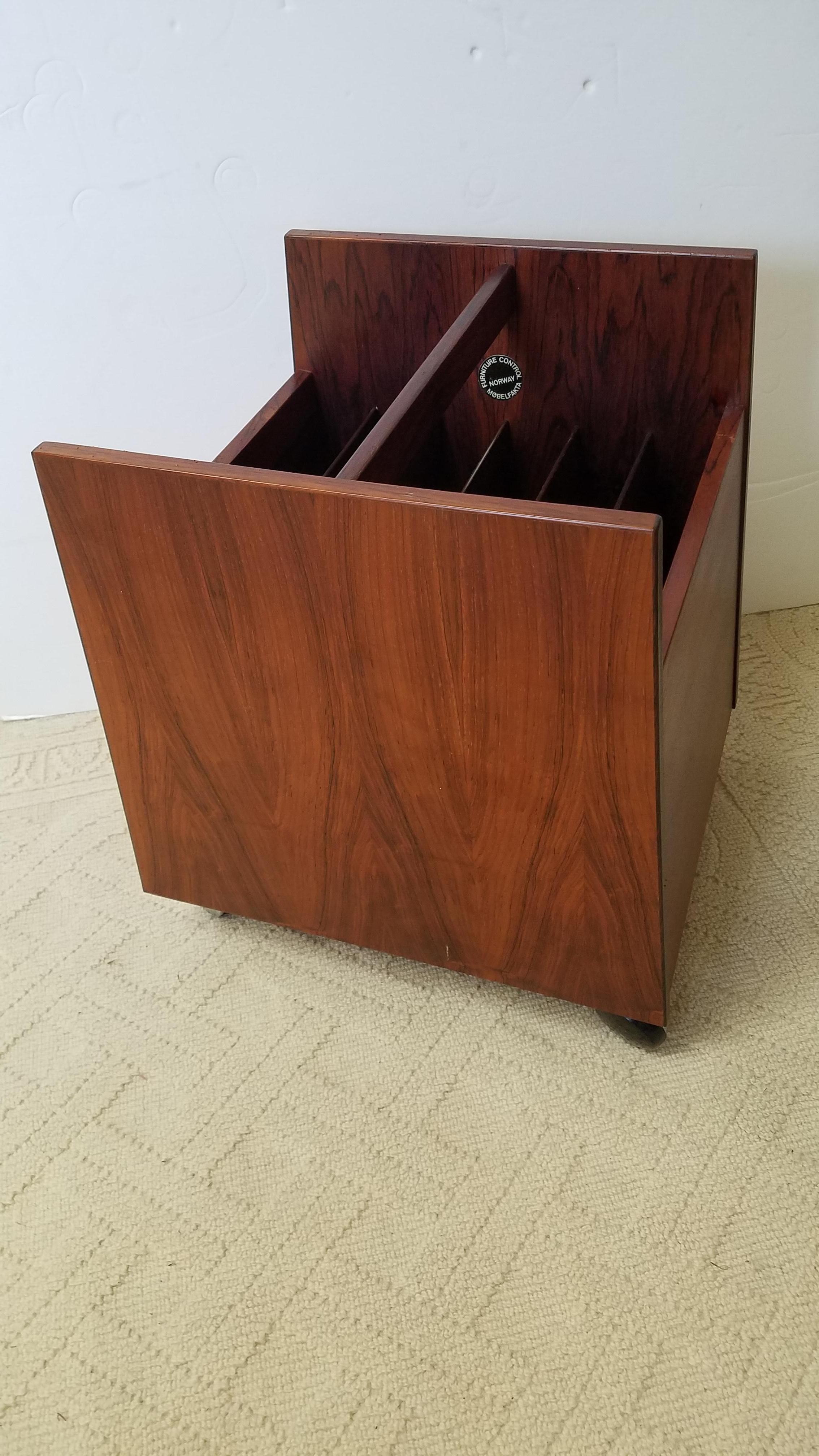 Midcentury Scandinavian rosewood magazine stand in excellent original condition. The body with 6 compartments with castors for easy movement... The wood having beautifully figured grain. Great as an LP holder of music stand.