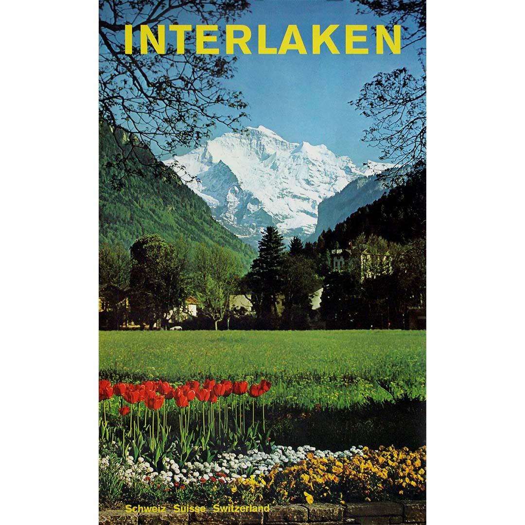 This beautiful original travel poster from circa 1970 was designed by Swiss photographer and poster artist Rolf Krebs, promoting Interlaken, one of Switzerland’s most iconic destinations nestled between Lake Thun and Lake Brienz.

The poster