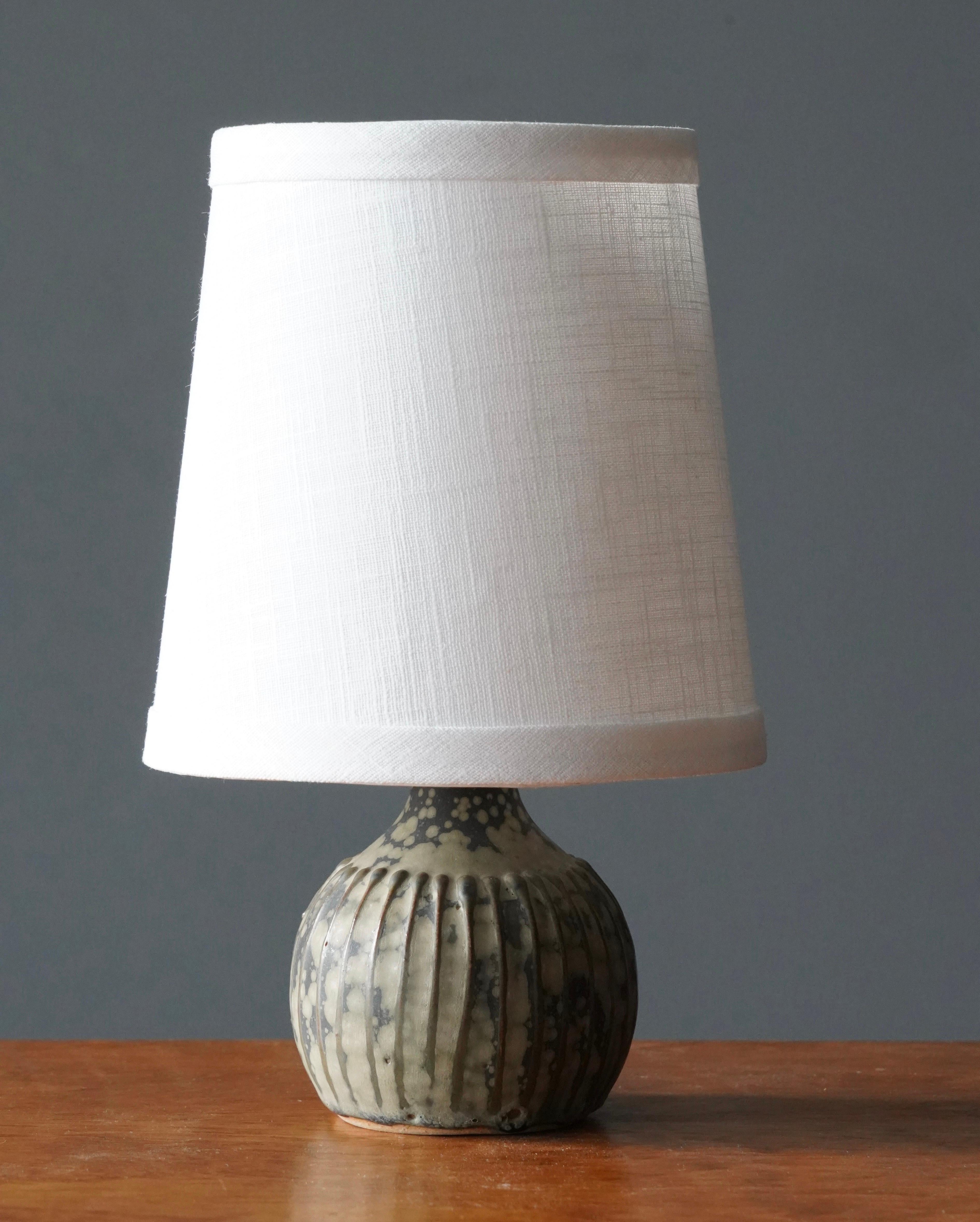 A small table lamp. Produced and designed by Rolf Palm, Sweden.

Dimensions listed are without shade. 
Dimensions with lampshade: height is 10 inches, width is 6.5 inches.
Dimensions of shade: top diameter is 4.5 inches, bottom diameter is 6