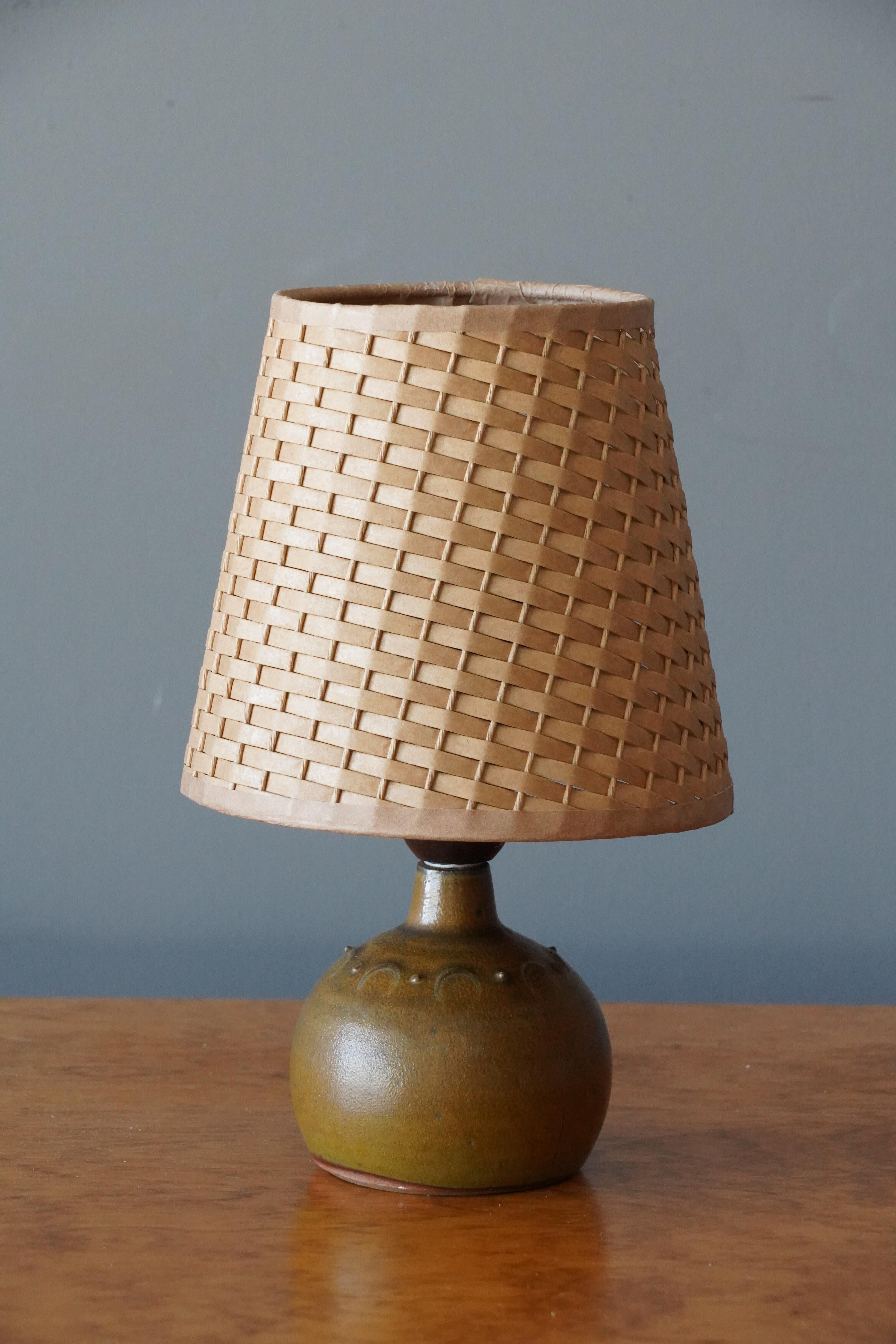 A small table lamp. Produced and designed by Rolf Palm, Sweden.

In glazed stoneware. Stated dimensions exclude lampshade. Height includes socket. Illustrated rattan lampshade can be included upon request.