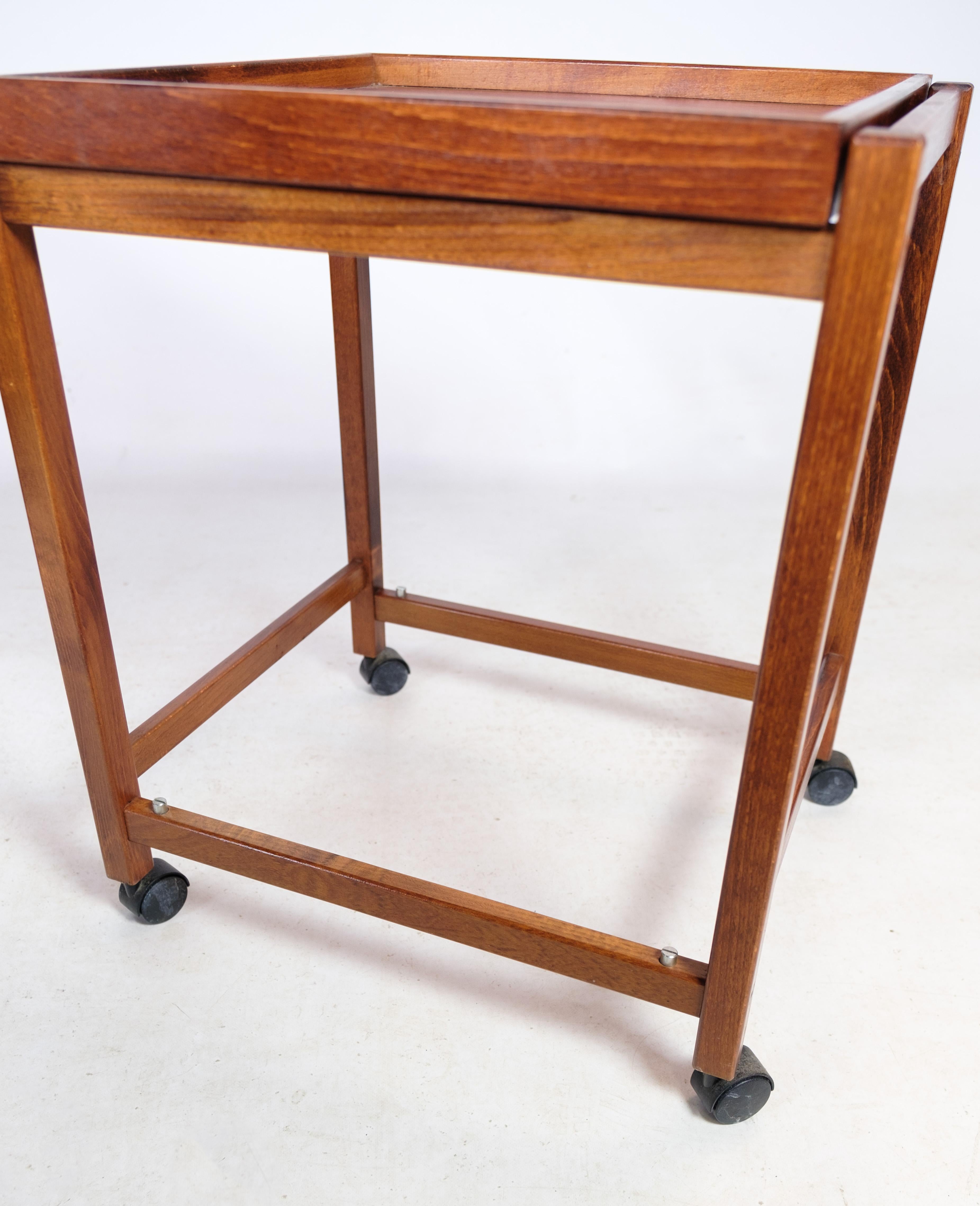 Small round coffee tables with 4 wheels and a serving tray both above and below made in walnut from around the 1960s.
Measurements in cm: H:56.5 W:47 D:42.