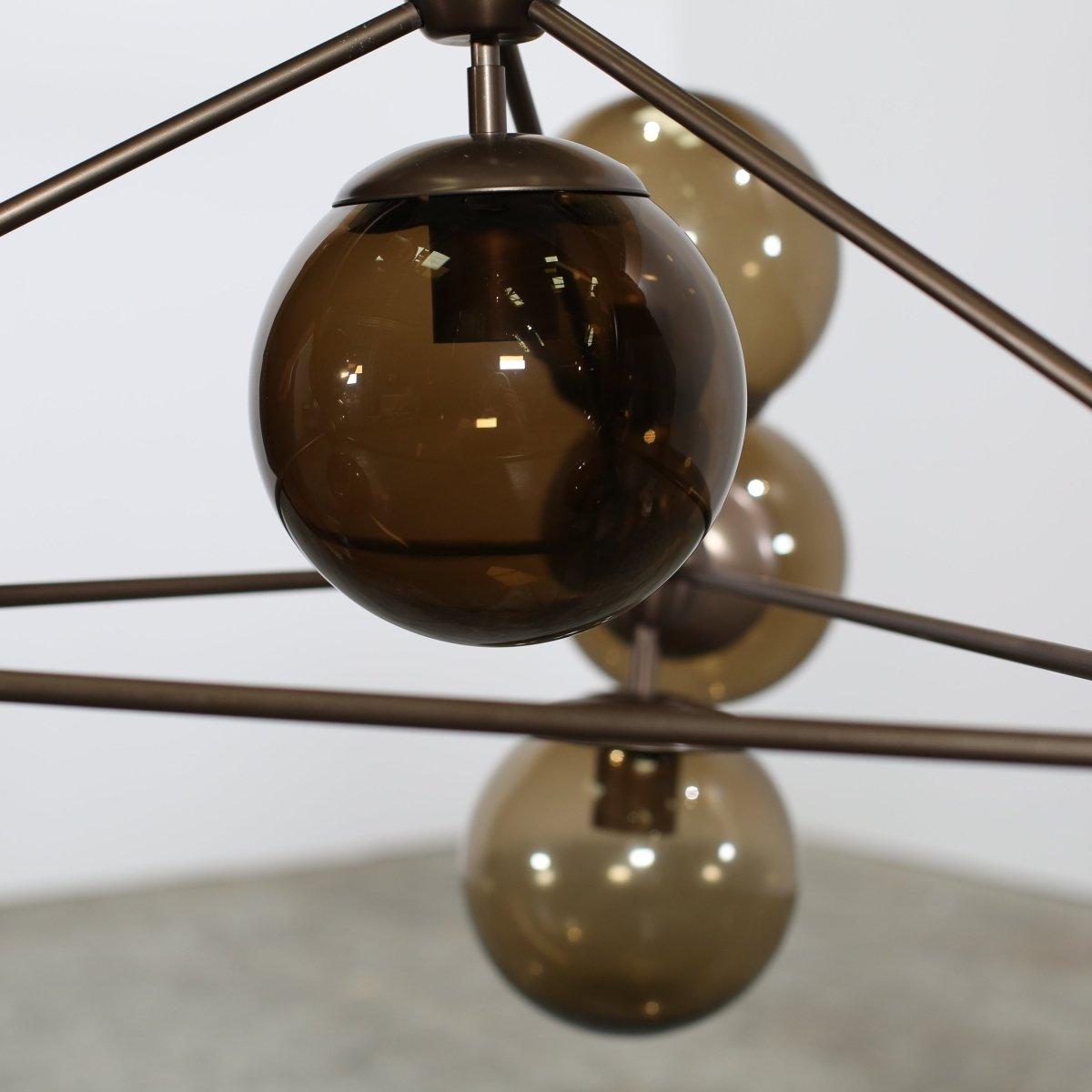 The Modo Chandelier by Roll & Hill is a striking, modular lighting fixture that blends industrial design with refined elegance. Its precise metal frame is paired with delicate glass globes to create a sculptural, contemporary silhouette. The Modo’s