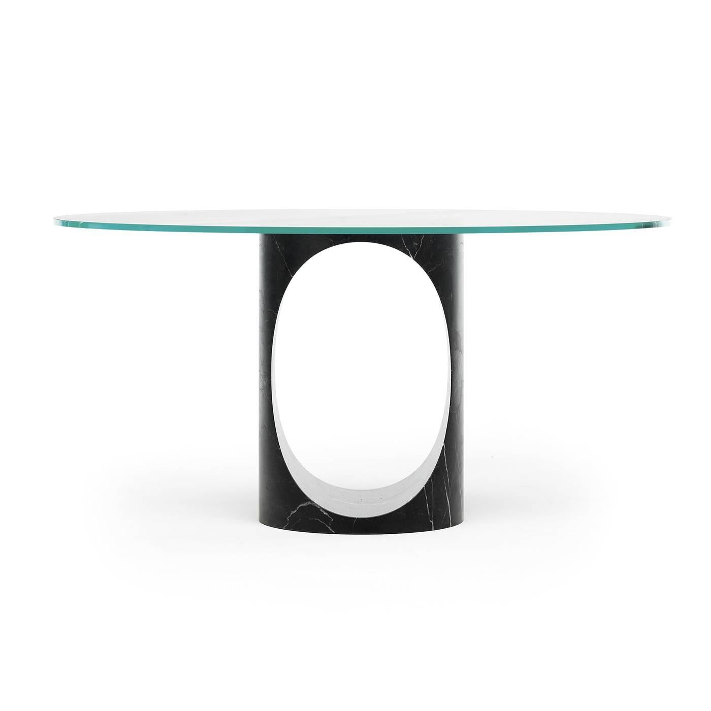 This superb dining table is modern and sophisticated, with a refined combination of contemporary design and noble materials. The base is carved from a single block of New Saint Laurent marble and boasts a dynamic silhouette enhanced by the striking