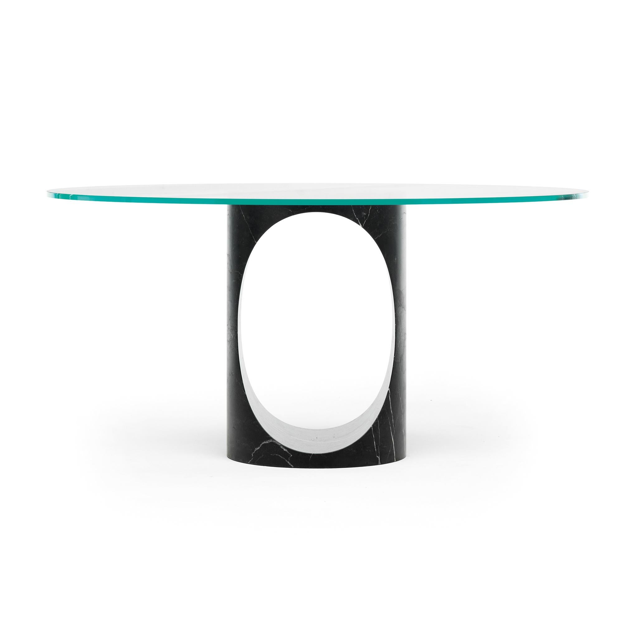 Roll is Epònimo’s central stem dining table. The base, carved from a single block of marble, is a geometric and yet organic sculpture that changes dramatically when viewed from different angles. Functionally it supports a thick but clear glass top