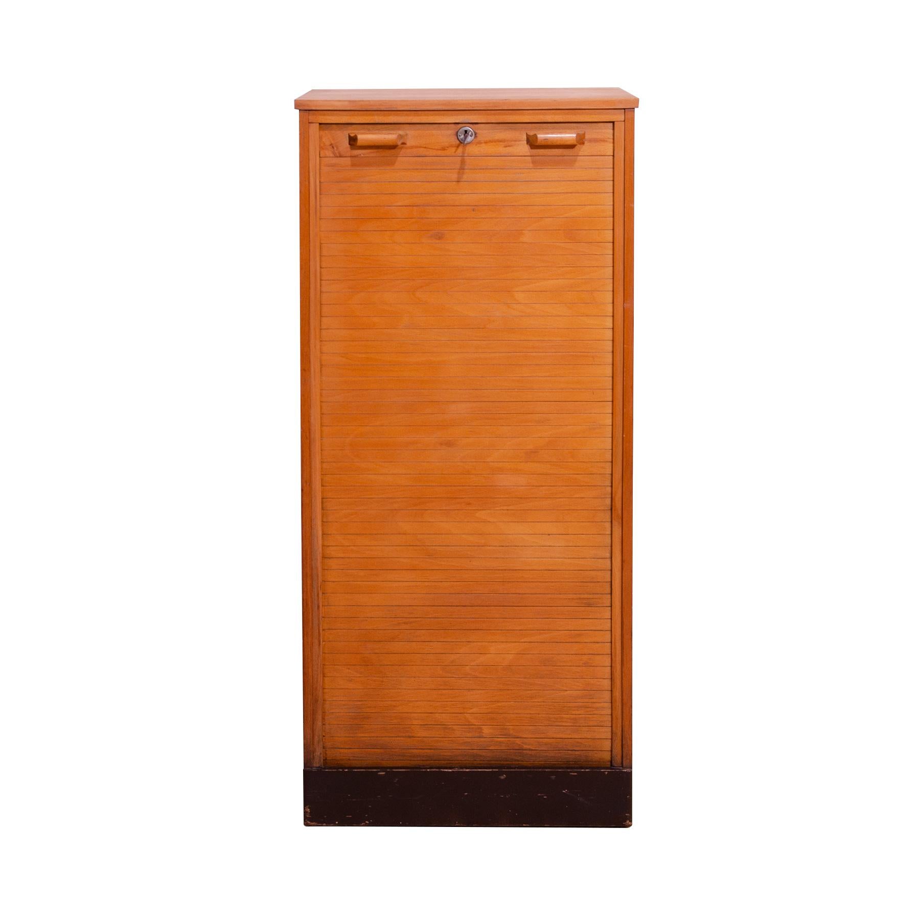 Roller blind cabinet made in the 1950s in the former Czechoslovakia. More precisely, in 1955 by the furniture company Interiér Praha. It is made of beech wood and plywood. The cabinet has a rolling opening mechanism. The outside has a total of 14
