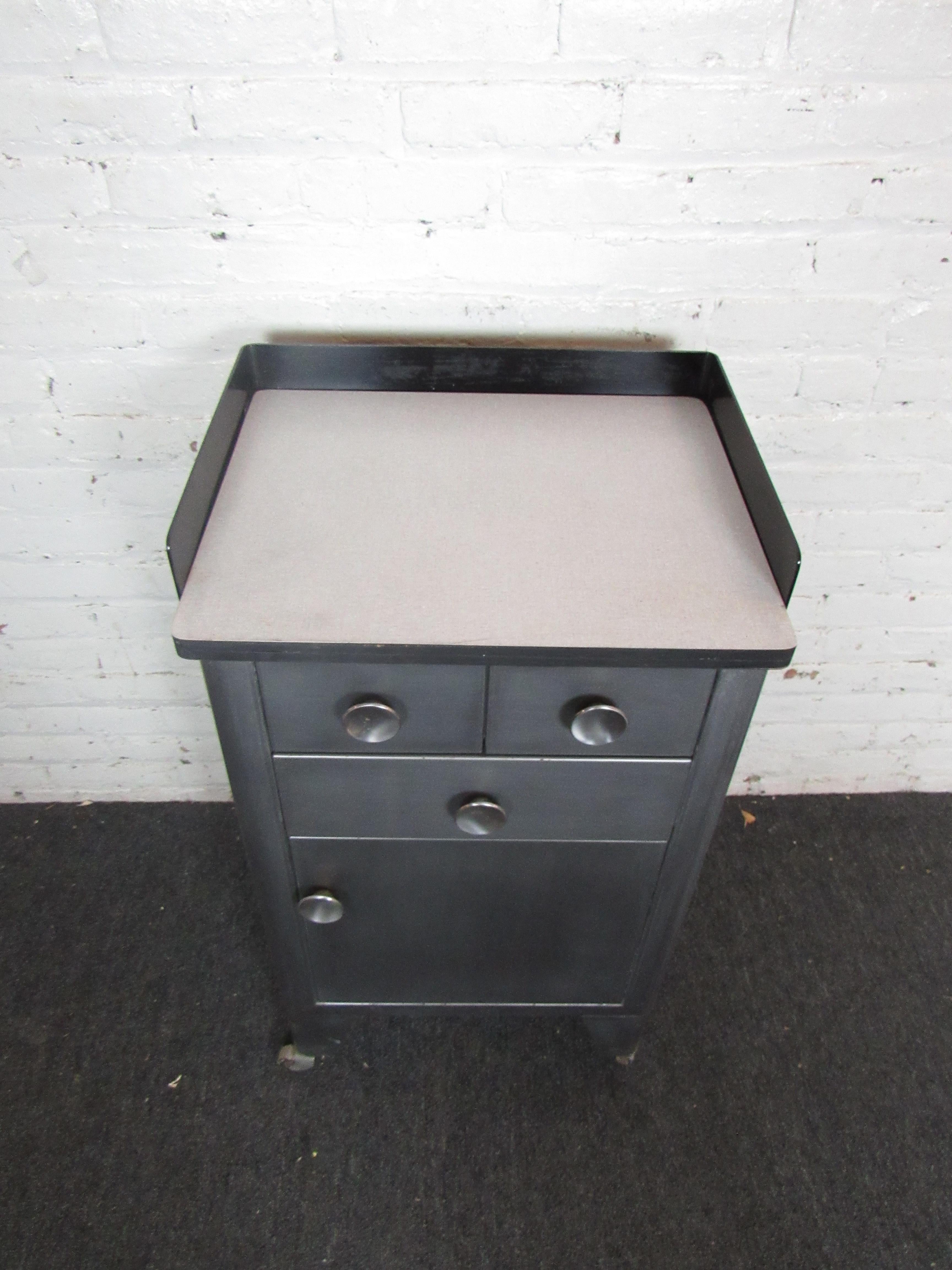 A sturdy industrial cabinet with three drawers and a door offering spacious compartments, this compact piece is built to last. Rolling wheels make this cabinet great for a garage, shop, or studio. Please confirm item location with seller (NY/NJ).