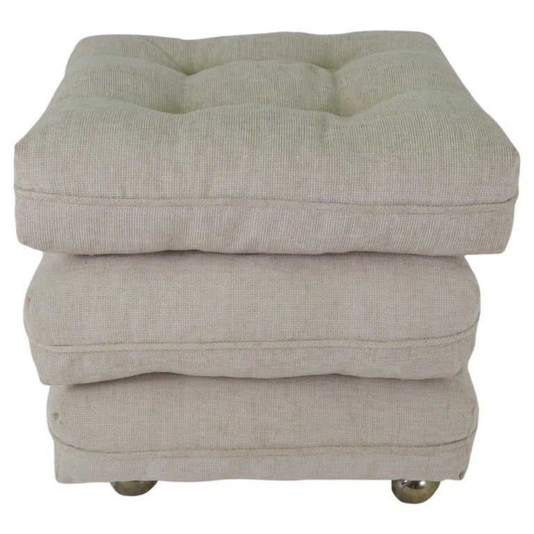 Newly reupholstered 1950s three cushion ottoman with the bottom cushion sporting casters making it a rolling piece and the top two cushions are loose, so they can be stacked in various positions and can be used alone however you like. Each cream