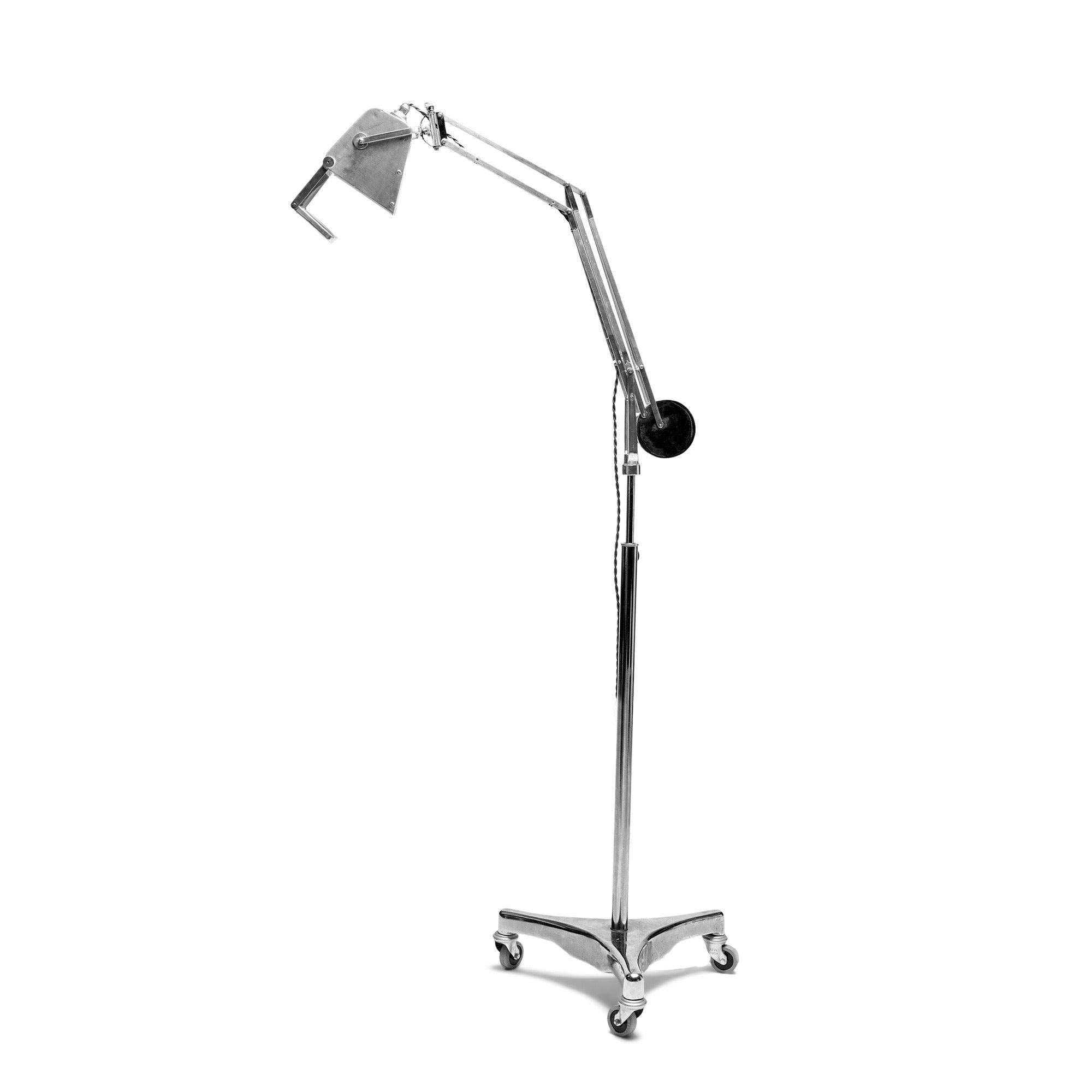 An exceptionally multi positional chrome, steel, and aluminum floor lamp with an adjustable stem on a tripod caster base.