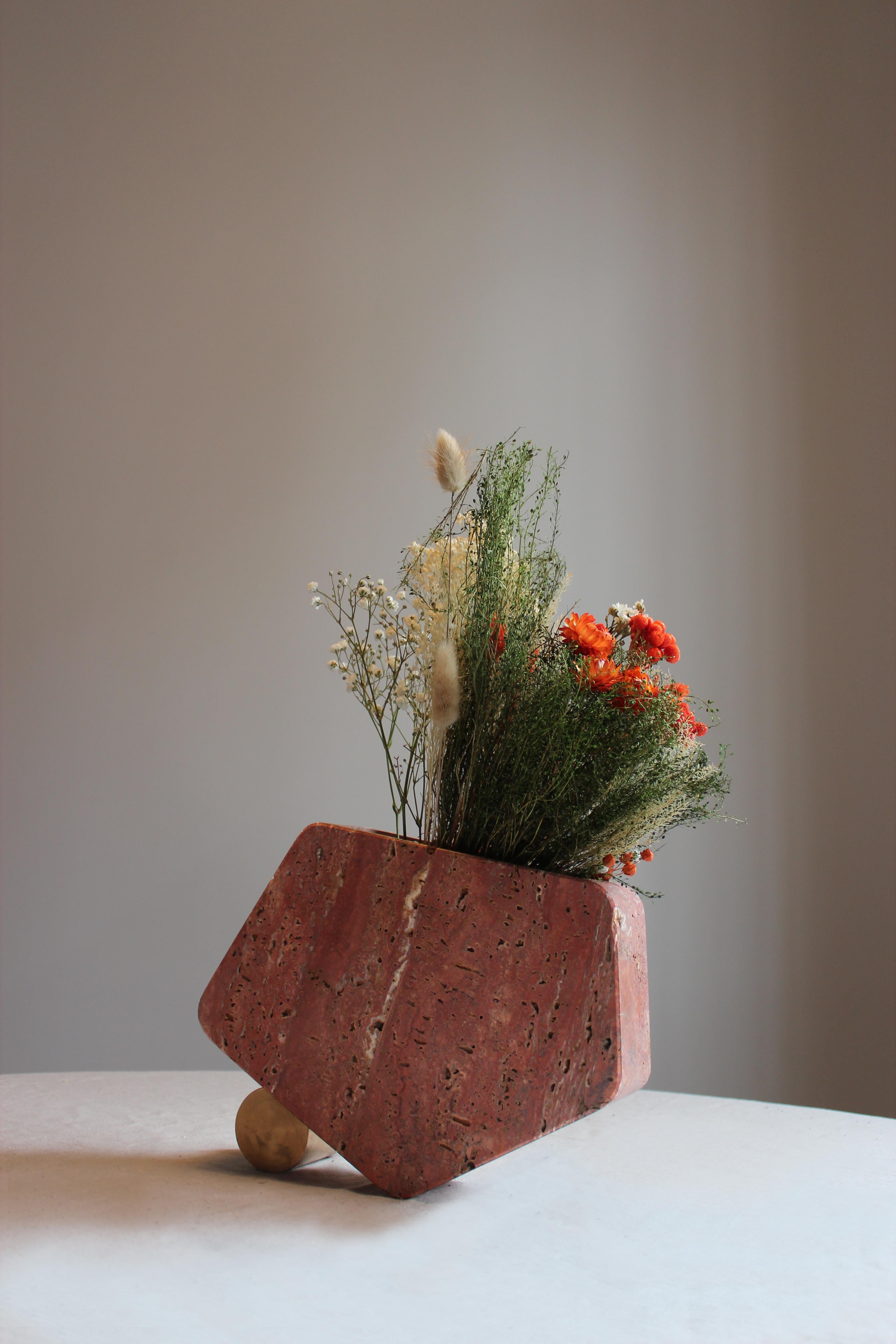 The Rolling Vase #3 is the result of the sculptural work made from our Atelier in order to generate a dialogue between two really different and contrasting materials. The Travertine presents itself in its intense Red colour and its porosity which is
