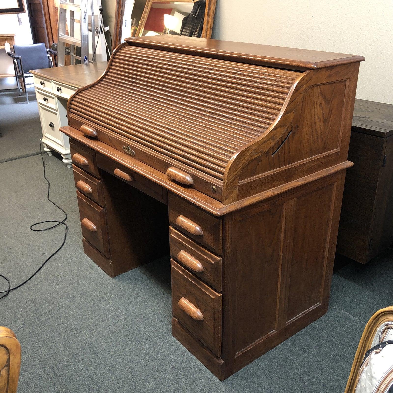 Vintage oak roll top desk. The desk has a number of different sized drawers for organization and storage. The roll top is fully functional. The finish shows age in a good way and retains its warm honey color.
