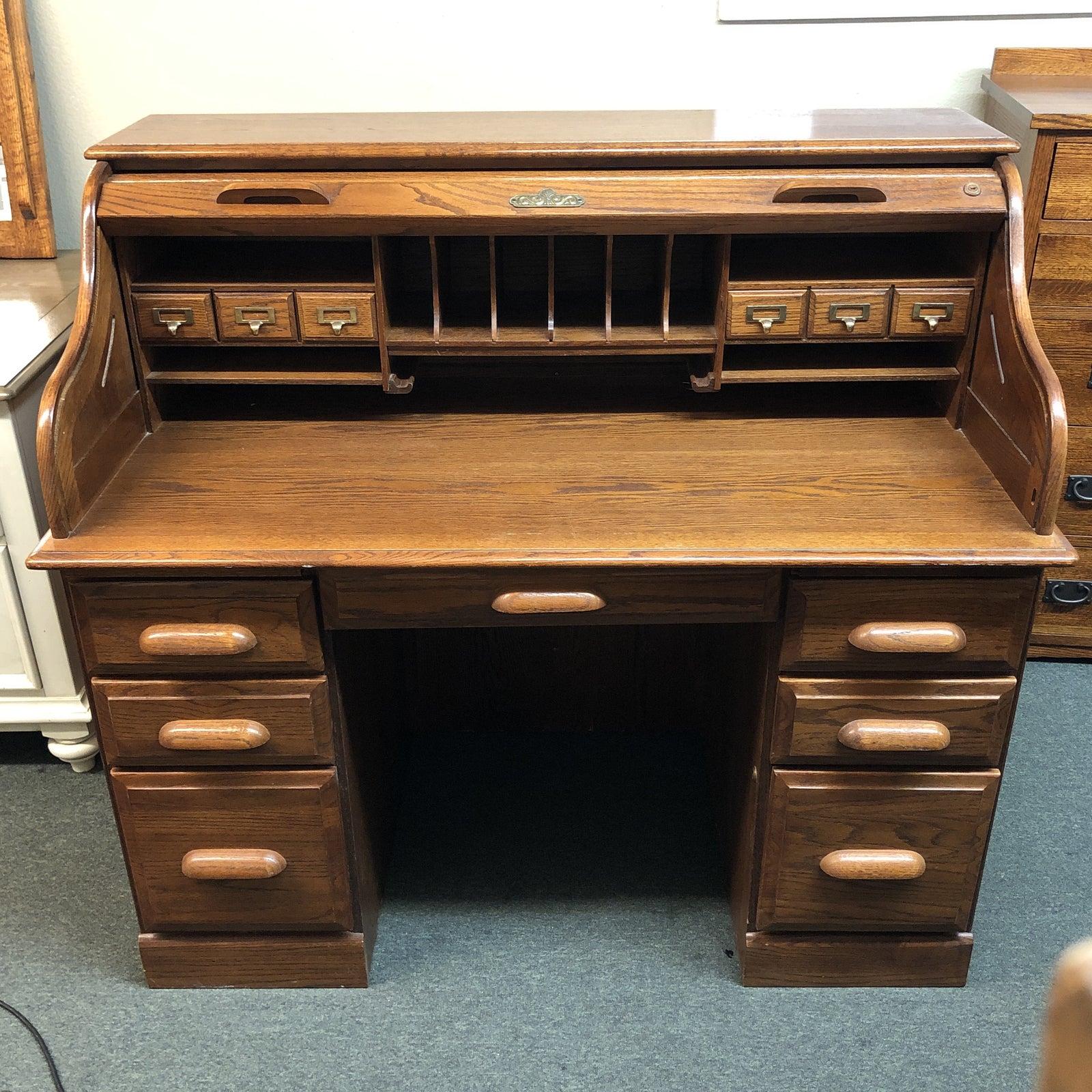 Avintage oak roll top desk. The desk has a number of different sized drawers for organization and storage. The roll top is fully functional. The finish shows age in a good way and retains it's warm honey color.