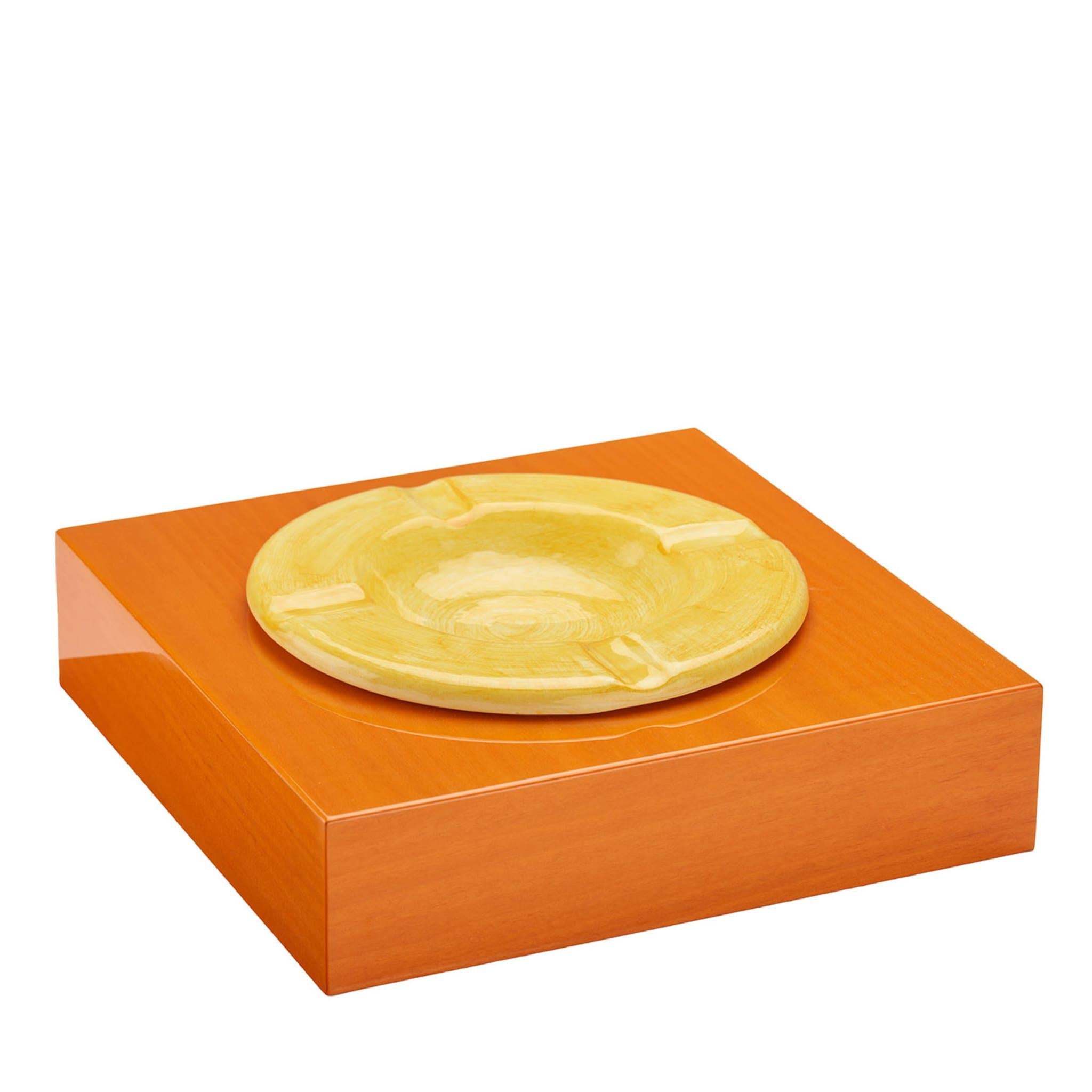 An everyday object becomes a refined piece of interior design in this splendid ashtray, a sublime display of artisanal craftsmanship. Showcasing natural veinings and grains through the polished orange and yellow paint decorating its square and clean
