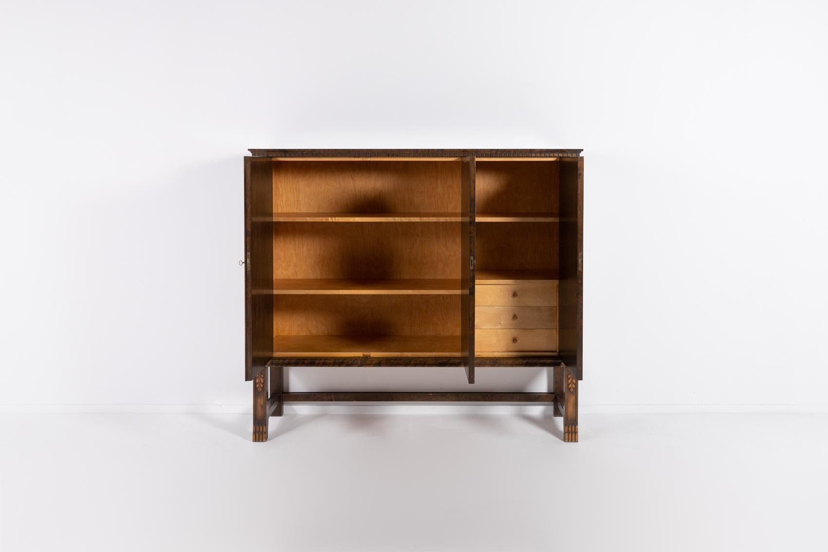 Art deco cabinet in flamed birch designed by Axel Einar Hjorth and made by Bodafors Sweden in 1920s. The dresser has 3 doors where behind them you will find three pull-out drawers and shelves.

Condition
Good, age related wear and marks, some
