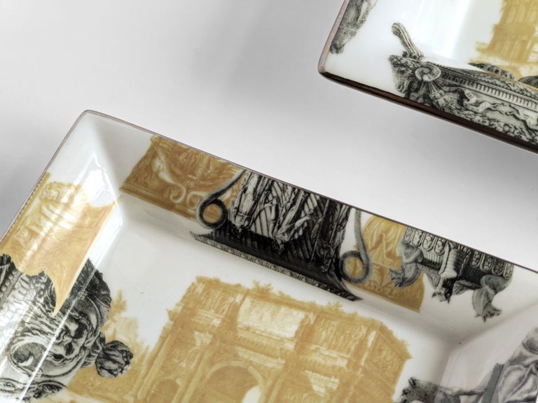 A set of two porcelain pocket emptiers/ashtray with a classic shape and unique printed design. This two pieces celebrates the eternal city of Rome through a meticulous and exquisite image of multiple ornamental vases depicted with stunning realism