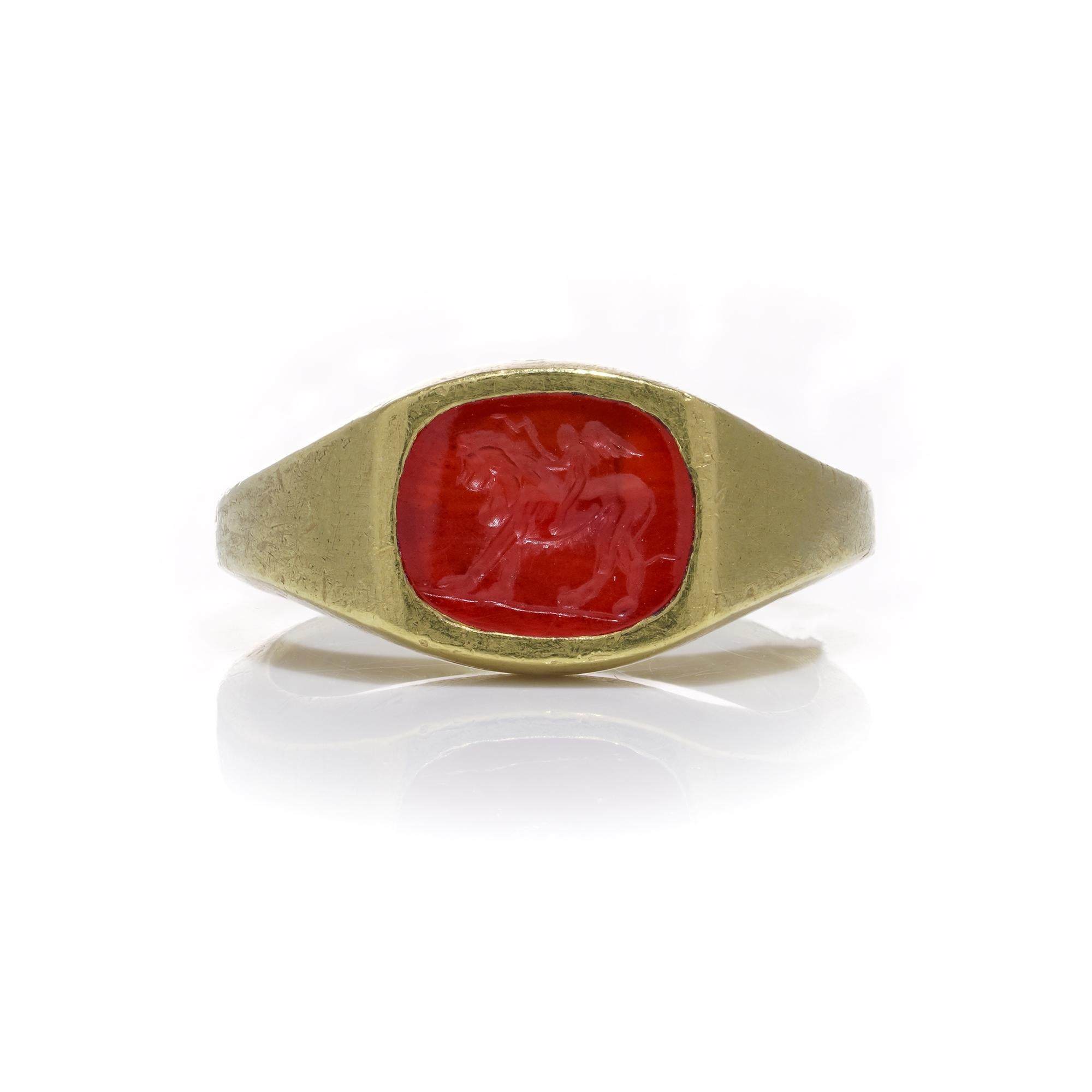 Oval Cut Roman carnelian intaglio with Cupid riding a Lion mounted in 22kt gold For Sale
