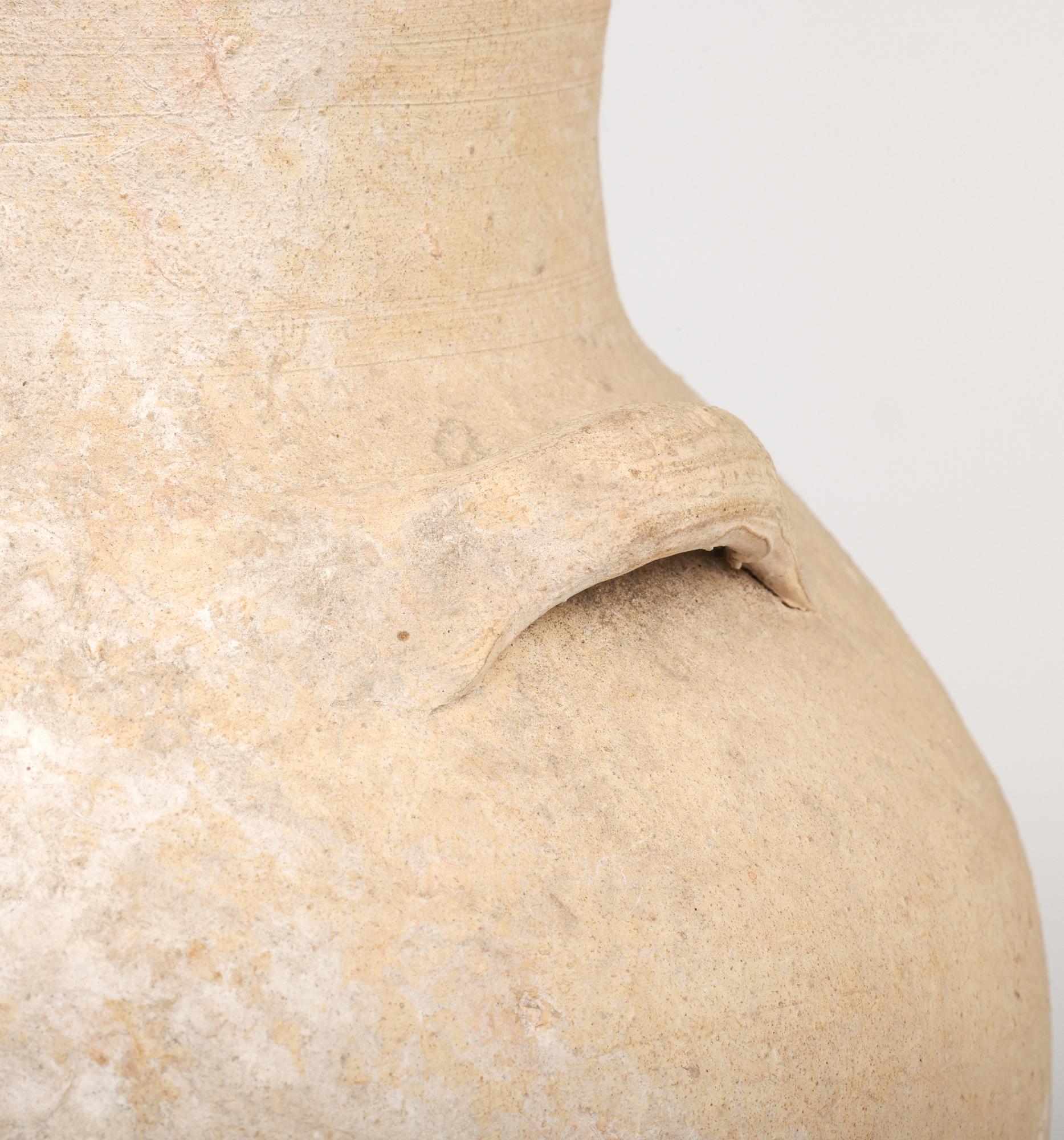 A stunning and very fine ancient Roman pottery amphora twin handled vessel dating from around 400BC. The lightly potted and unglazed vessel stands on a small round base with a tall round bulbous body with a funnel shaped neck and folded back flat