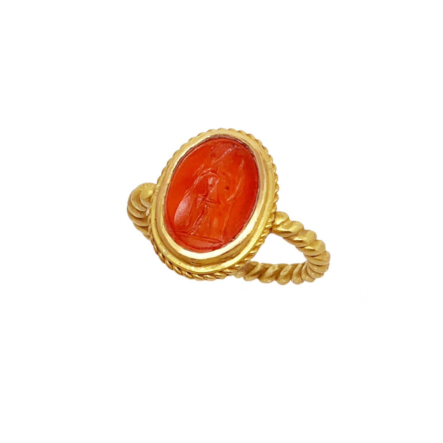 This gold ( 20 K ) ring, with an authentic Roman carnelian (1st cent.A.D.) belongs to SERRA  archeological collection, that use genuine ancient Roman coins and intaglios. 
In the center of the ring , the roman intaglio depicts goddess Athena.  She