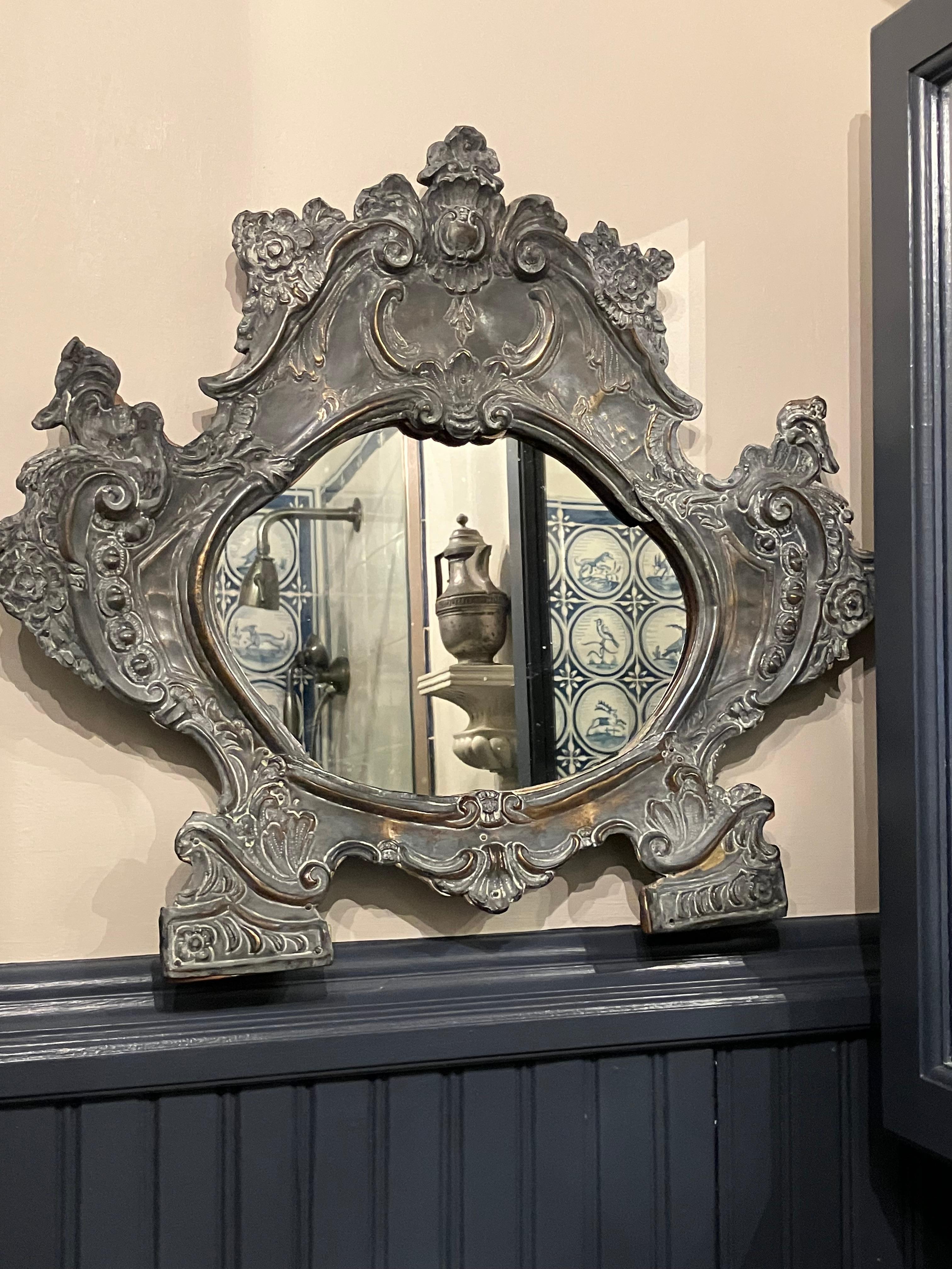 Specchio romano barocco in metallo. Specchio barocco a forma di cartiglio in ottone patinato. Specchio sostituito. Italia, c. 1700

Dimensioni approssimative: 19,25