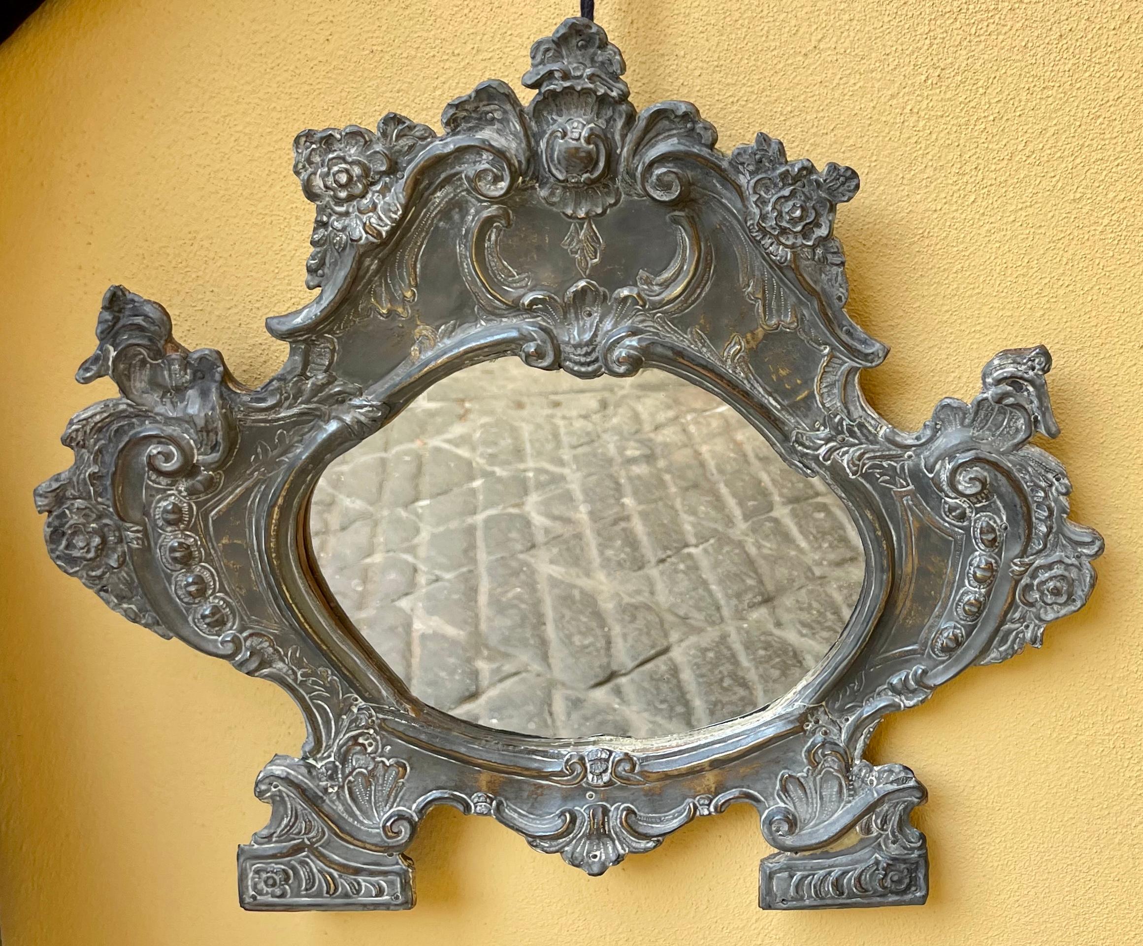 Roman Baroque metal mirror. Patinated brass baroque cartouche form mirror. Mirror replaced. Italy, c. 1700

Approximate dimensions: 19.25