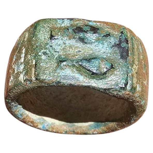 Intéressante bague romaine du 1er siècle ADS, coulée en bronze et décorée d'un motif gravé de deux poissons se faisant face, un symbole courant dans le monde antique, associé à la fois à la fertilité et, plus tard, au début du christianisme. Cette
