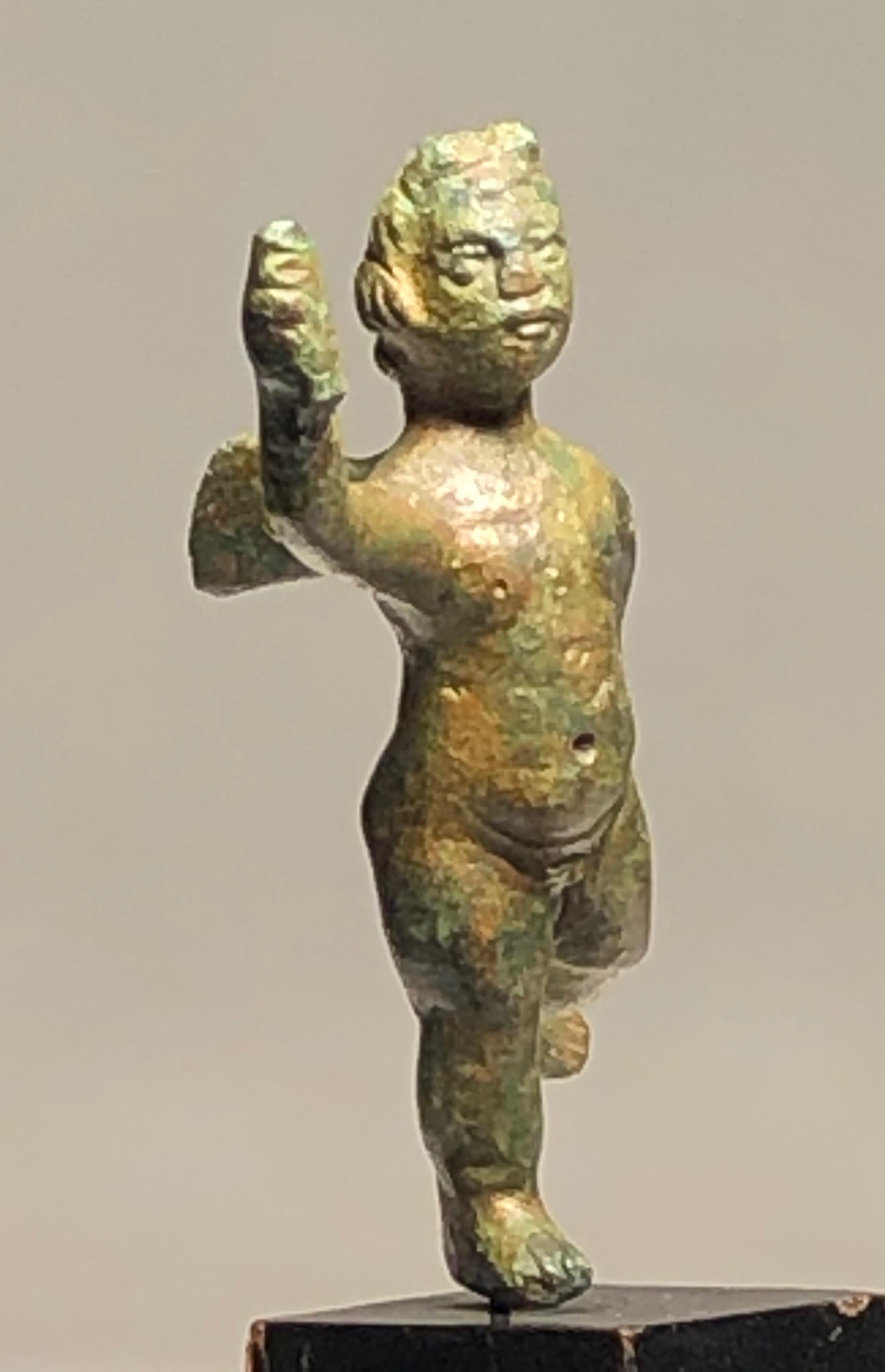 Charming Roman bronze statuette of a young Cupid, the Roman counterpart of Eros in Greek mythology; the young winged god of love and sex. Eros, Son of Aphrodite (Venus) and Ares (Mars) had many siblings with whom he formed groups of winged love