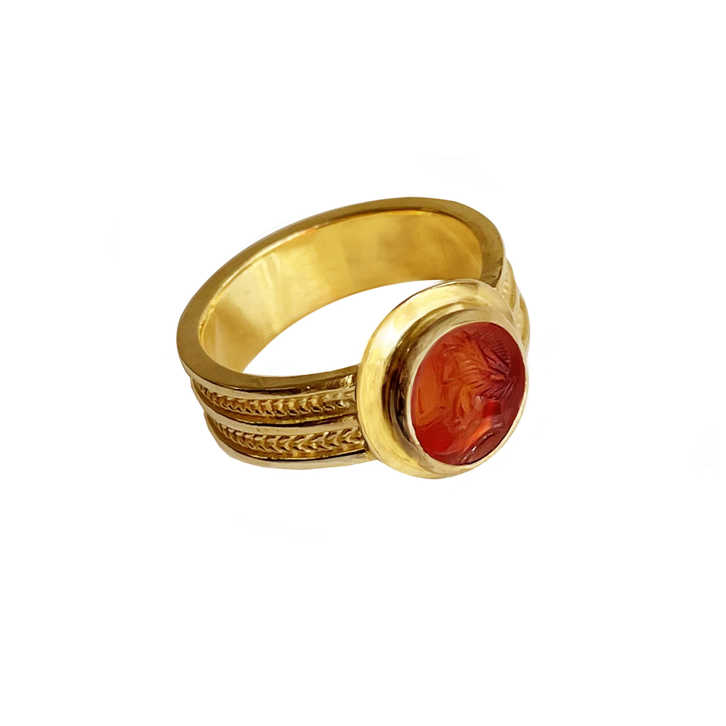 In this amazing ring handmade by our goldsmiths in 18 Kt gold  is set an authentic Roman carnelian intaglio (1st-2nd cent AD) depicting the head of the God Apollo.
Apollo was considered the standard of male beauty ! He was the son of Zeus and Leto.