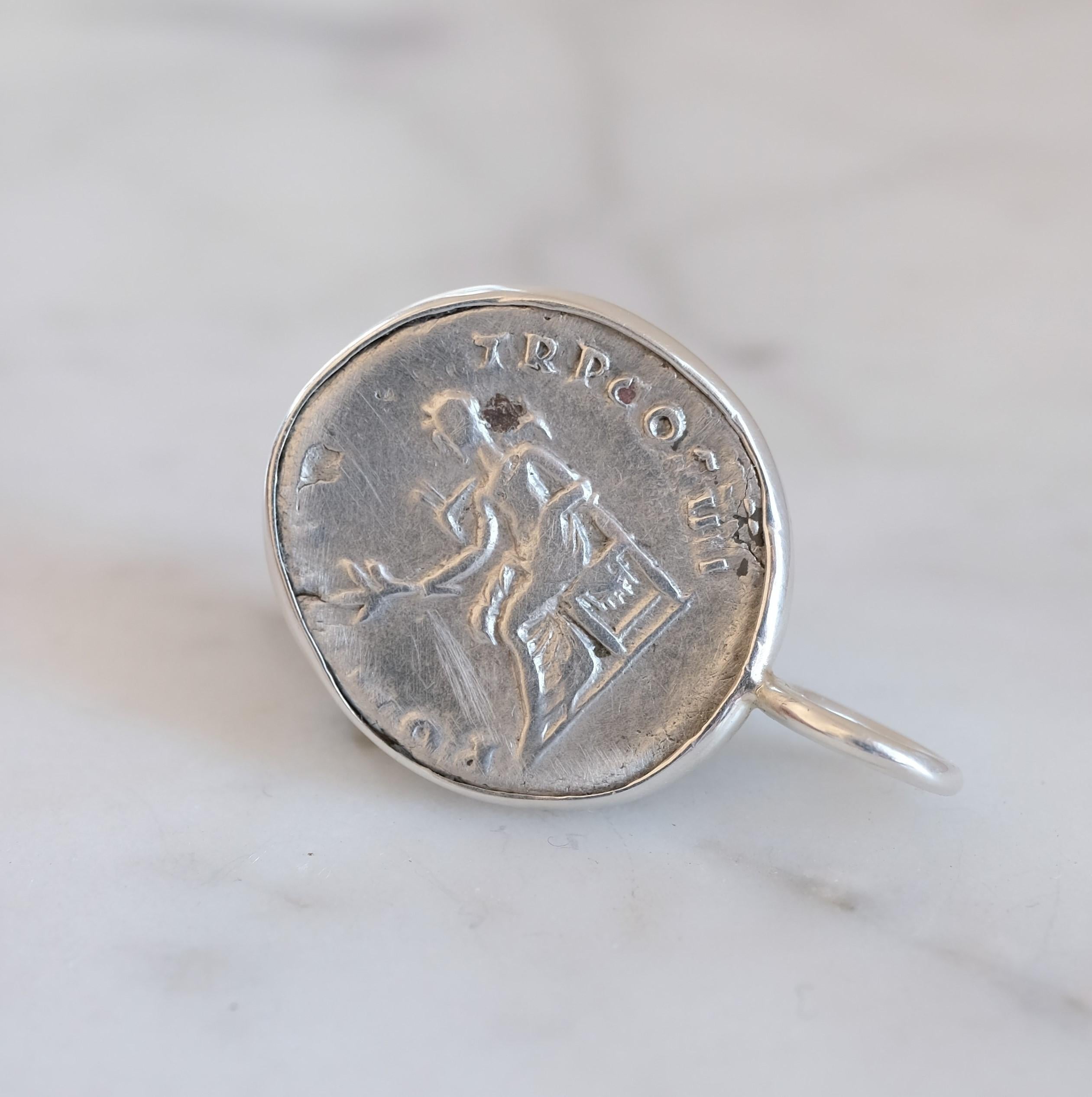 Pour apprécier la taille du pendentif, le relief de la pièce et la forme de l'écrin, voir la photo montrant la pièce à côté d'une pièce de 25 cents (à venir). La pièce a d'abord été sertie dans un chaton en argent sterling, qui a ensuite été martelé