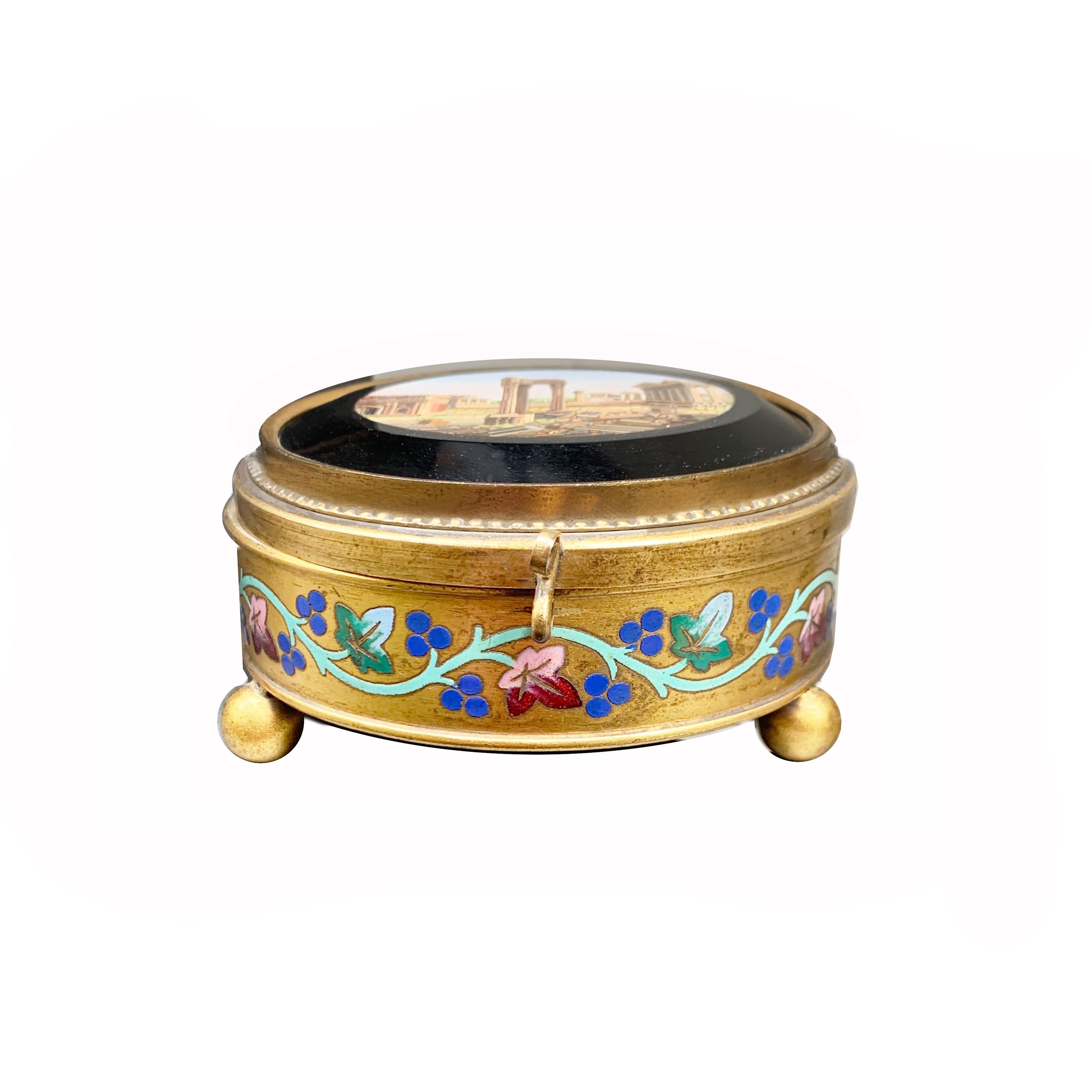 Dans cette boîte en bronze doré à 24 kt, ornée de motifs floraux peints à la main, se trouve une magnifique micromosaïque (vers 1850) représentant le Forum romain.
Le 