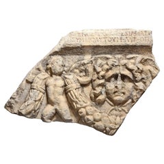 Fragment romain de sarcophage représentant un Gorgone et Eros avec une épine dorsale