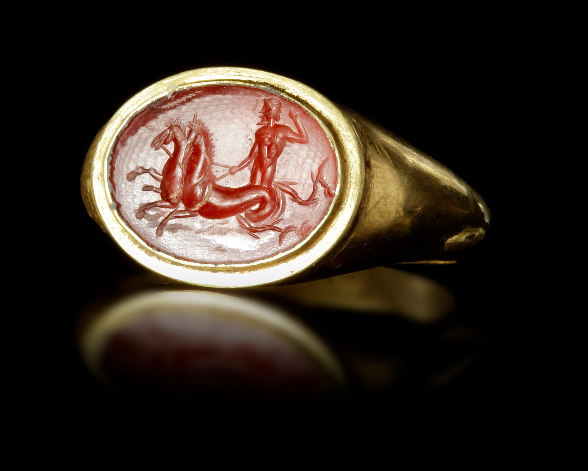 A Roman gold ring made from thick gold sheet holding an intaglio of Neptune/Poseidon being pulled by two Hippocamps. Of good work from the time of Augustus.
Size: 7
Weight: 3.60 grams