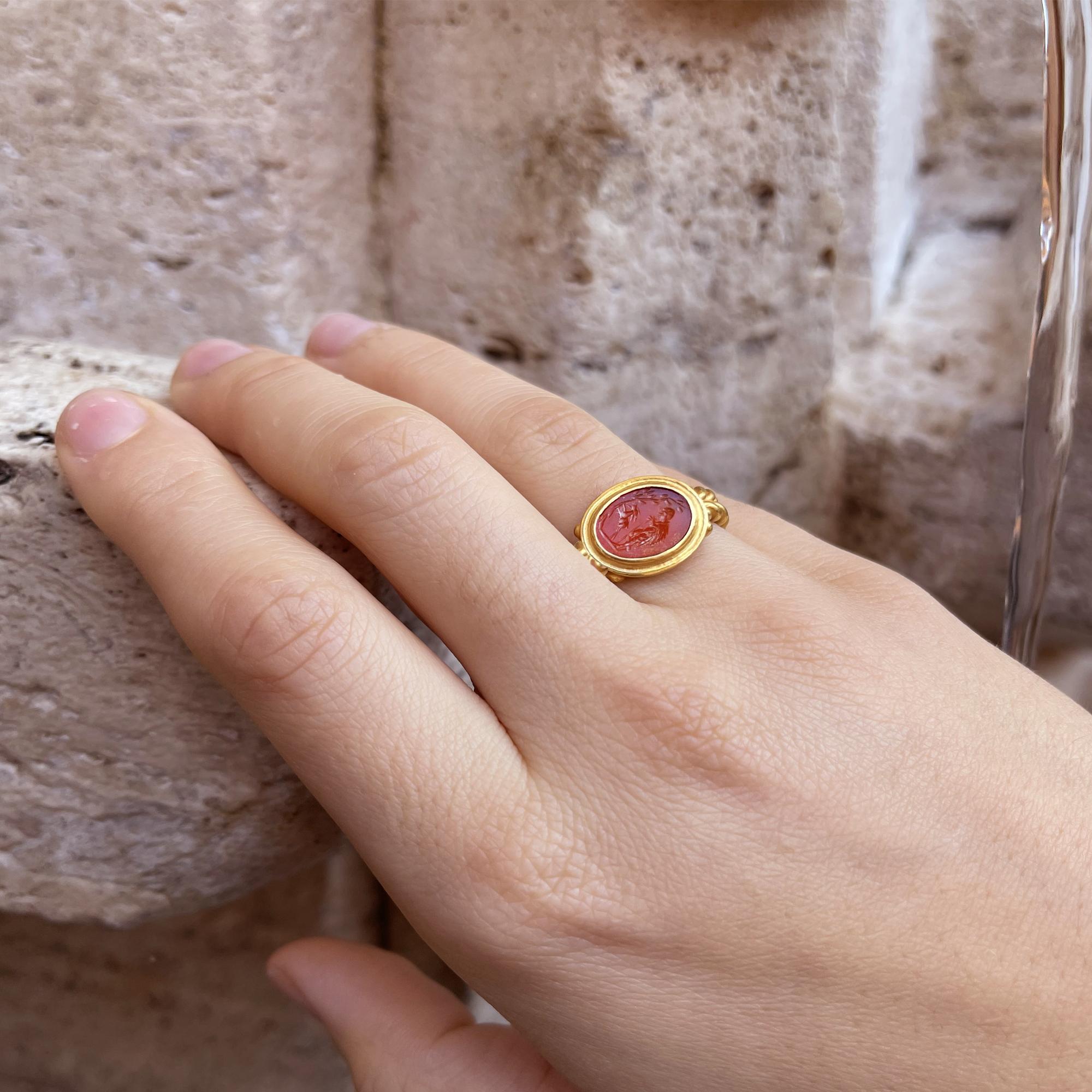 An authentic Roman carnelian from the 1st-2nd century AD has been set in this 18 kt gold ring which depicts the goat Amalthea resting with the two front legs on a tree, and a shepherd behind her. The mythology says that Jupiter was the son of