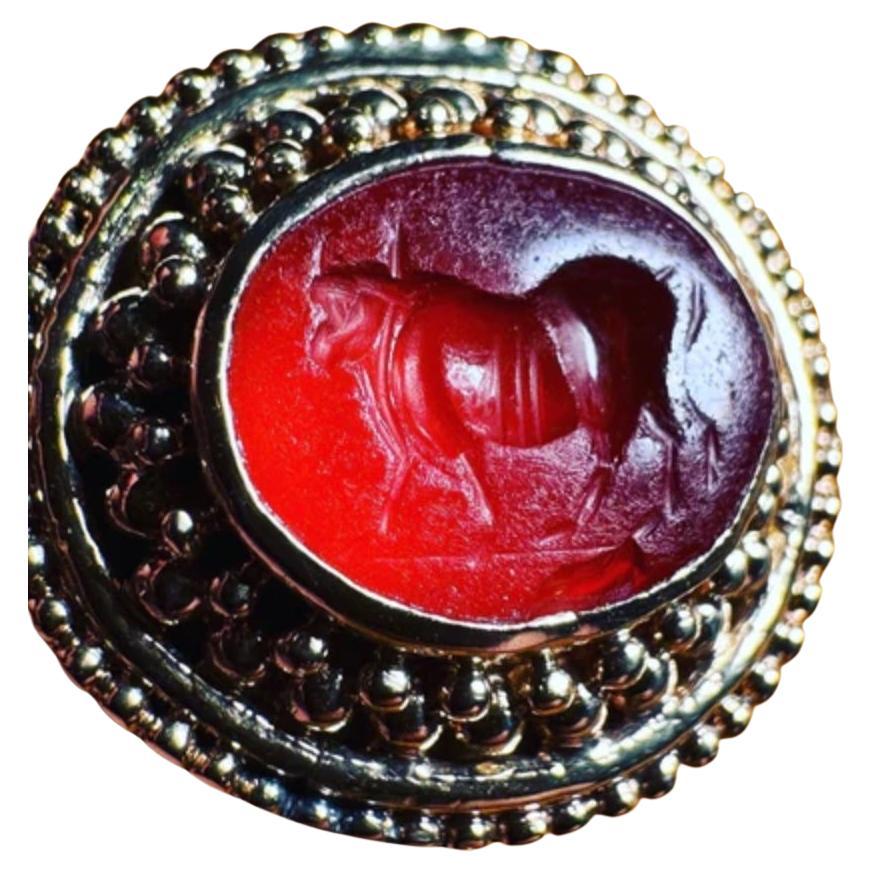 Indulge in the captivating allure of this beautiful Roman intaglio ring, meticulously crafted in luxurious 18K gold. This exceptional piece showcases a remarkable bull signet, a symbol of strength and power, expertly engraved into a stunning