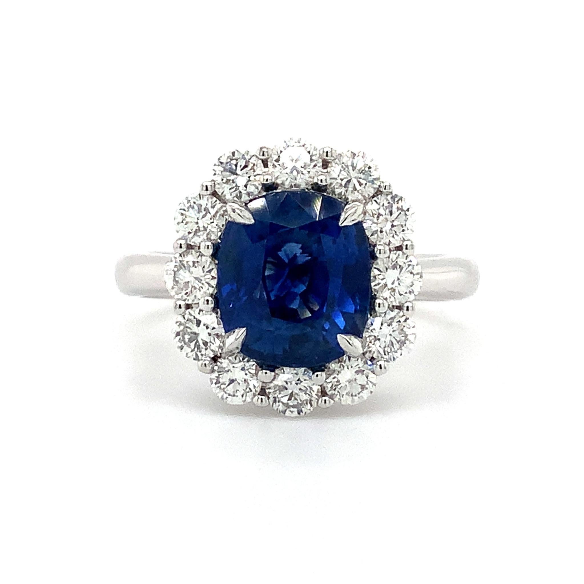 This exquisite Roman + Jules Classic Design is set with a 3.32ct Cushion Mix Cut Ceylon Blue Sapphire, accompanied by 26 Round Brilliant Cut Diamonds, all set in 18 Karat White Gold. The delicate Fillagree Gallery and melee diamonds set at the base