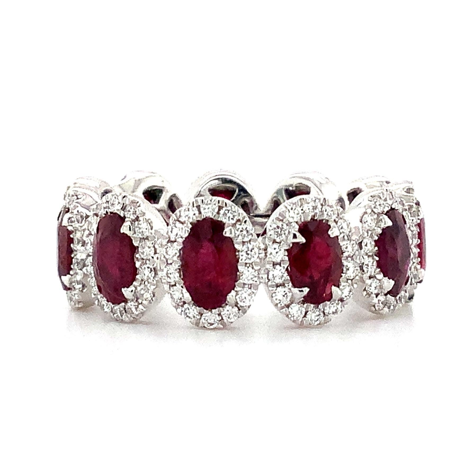 Cette magnifique bague d'éternité Roman + Jules en rubis ovale et diamant de qualité gemme est soigneusement fabriquée en platine. Ces impressionnants rubis présentent une teinte riche et profonde, encore accentuée par le halo de 4,04 ct. tw de