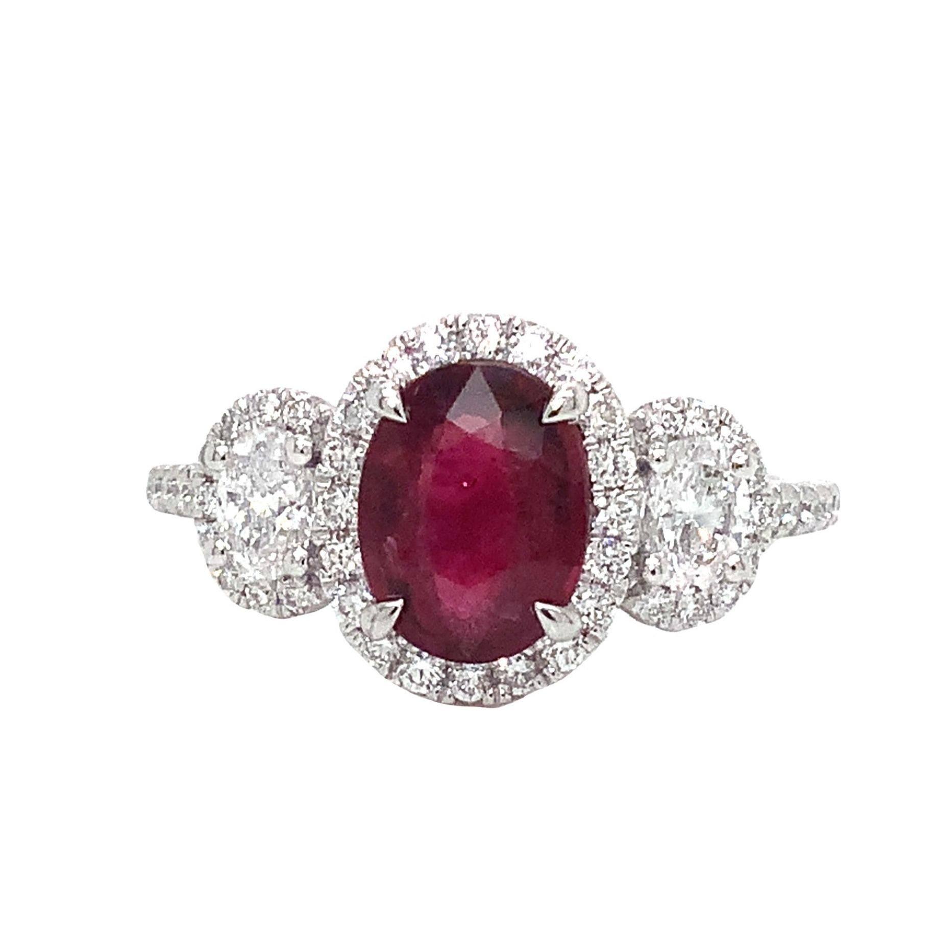 The 950 Platinum Roman + Jules 3 Stone Ruby and Diamond Ring Set features a 1.34 carat, oval-shaped Ruby at its center with GIA Certificate# 5202650310. Boasting a Dark Medium Crimson Red Color and Very Good Clarity Make and Polish, this