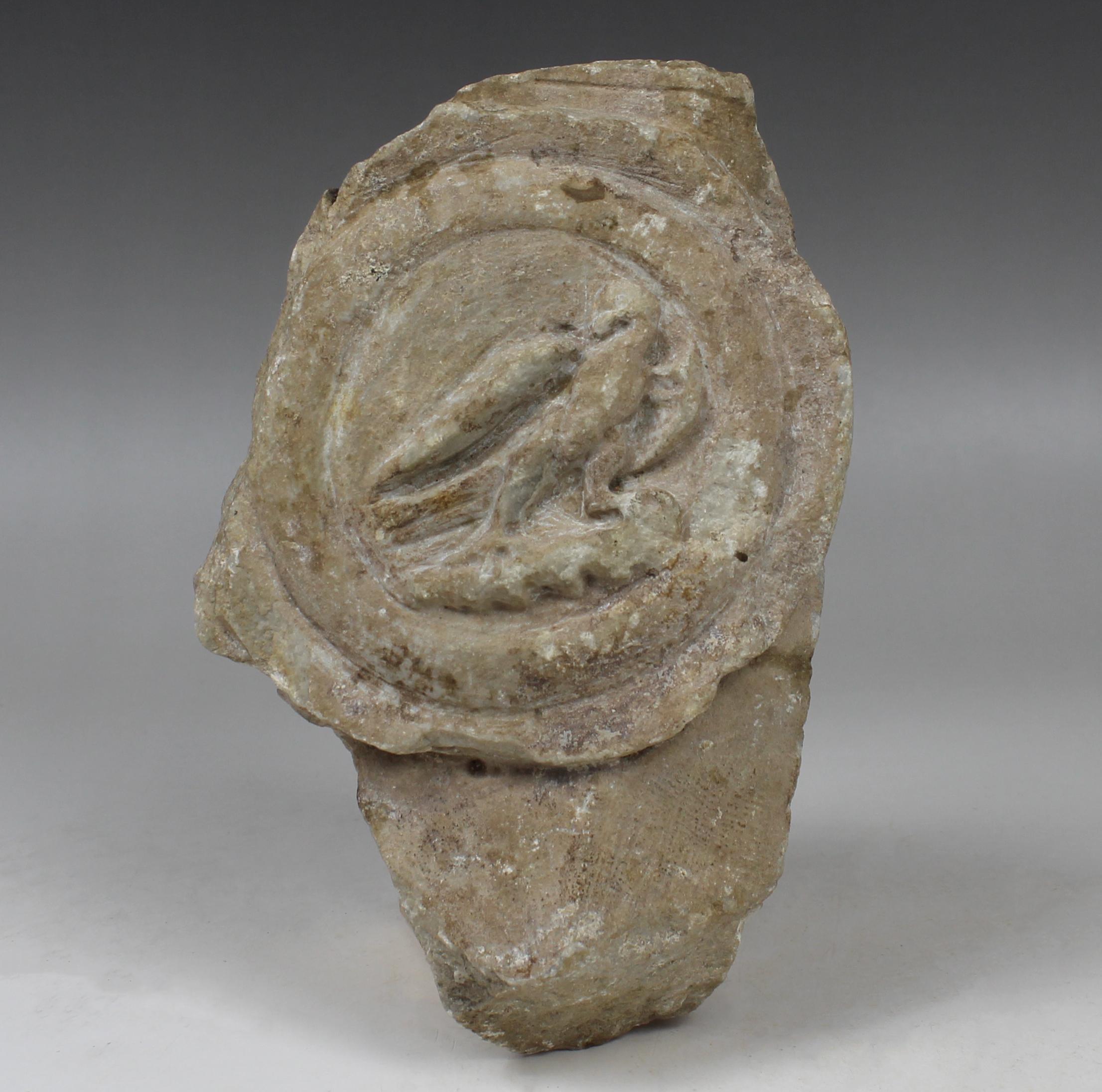 ITEM: Lorica thoracata depicting a medallion with eagle, fragment
MATERIAL: Marble
CULTURE: Roman, Smyrna
PERIOD: 1st – 2nd Century A.D
DIMENSIONS: 175 mm x 115 mm x 52 mm
CONDITION: Good condition
PROVENANCE: Ex Paul Gaudin collection, Paris 1858 –