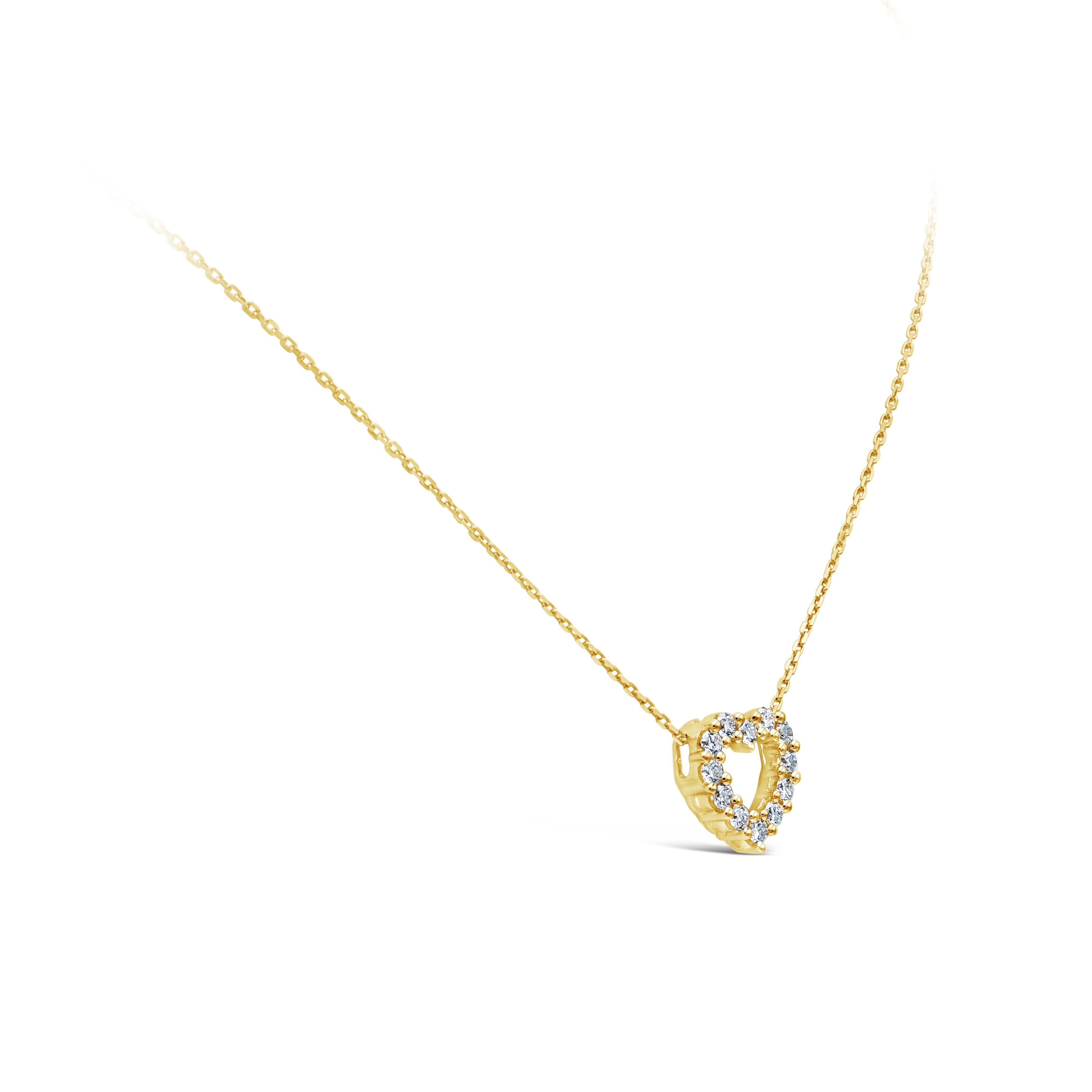 A simple pendant necklace showcasing a row of 12 round brilliant diamonds, set in an open-work heart shape mounting made in 18k yellow gold. Diamonds weigh 0.34 carats total, G color, VS-SI in clarity. Suspended on a 16 inch adjustable yellow gold