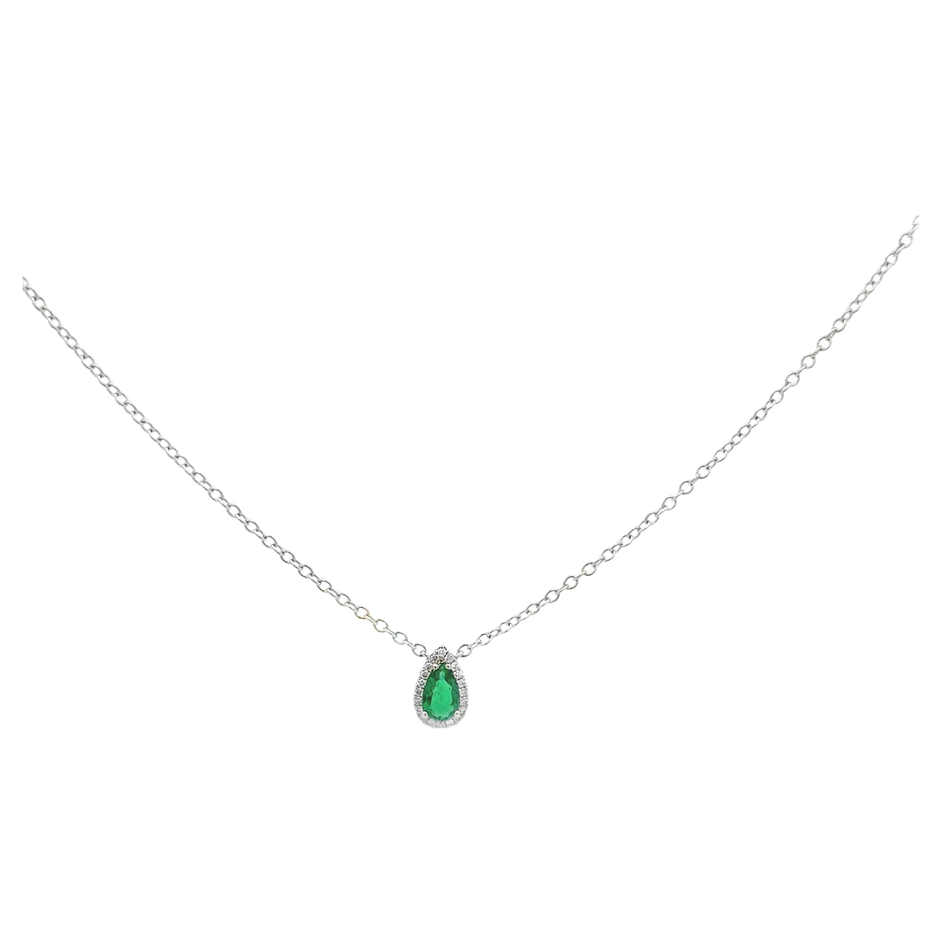 Una deliziosa collana con ciondolo, con uno smeraldo a forma di pera da 0,34 carati, incastonato su quattro punte arrotondate. Accentuato da un'aureola di diamanti taglio rotondo per un peso totale di 0.07 carati, incastonati in una montatura