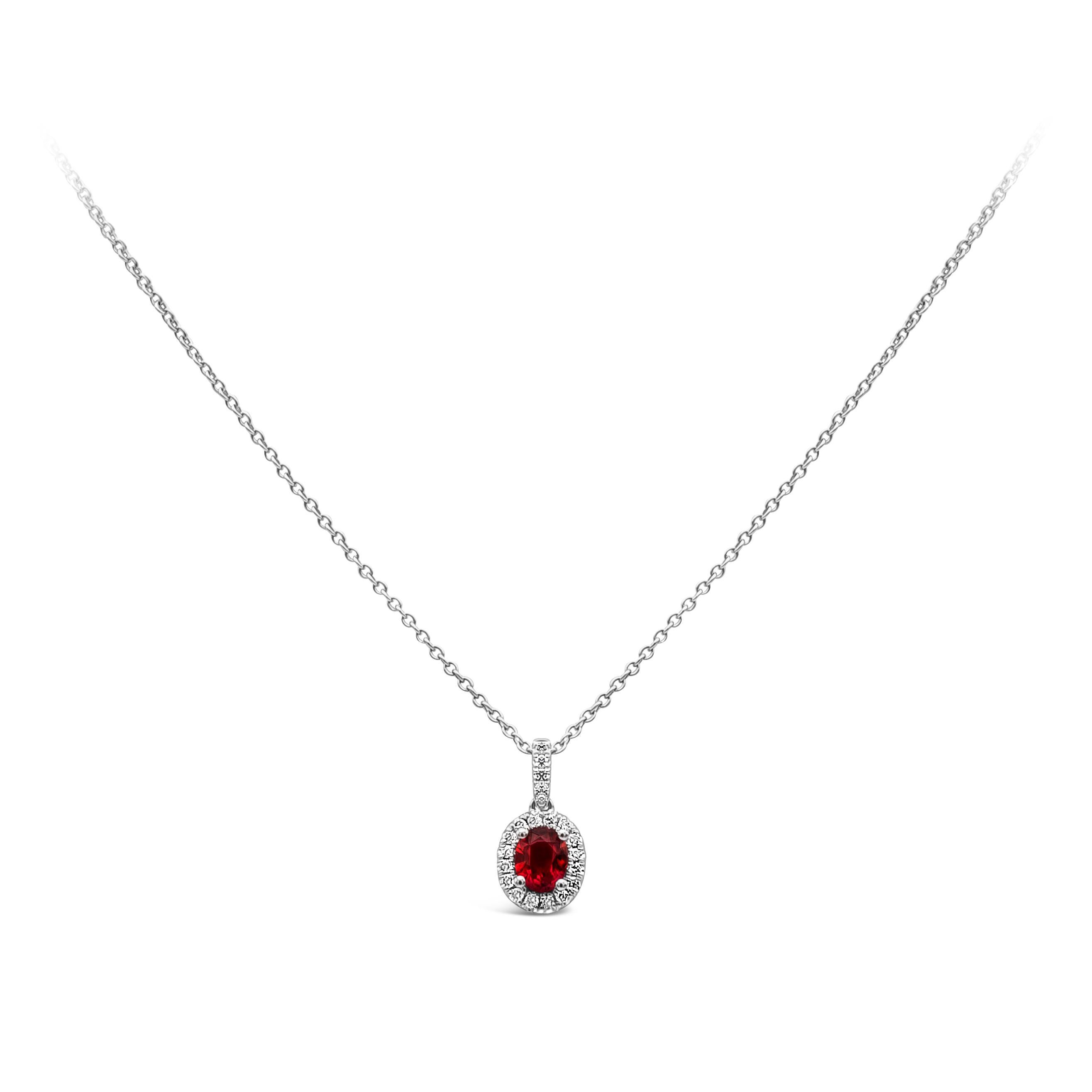 This fancy and unique halo pendant necklace showcasing an oval cut ruby weighing 0.38 carat, embellished by 21 pieces of round diamonds, weighing 0.10 carat total, F color and VS in clarity. Made with 14k and 18K White Gold. Suspended on 18 inches