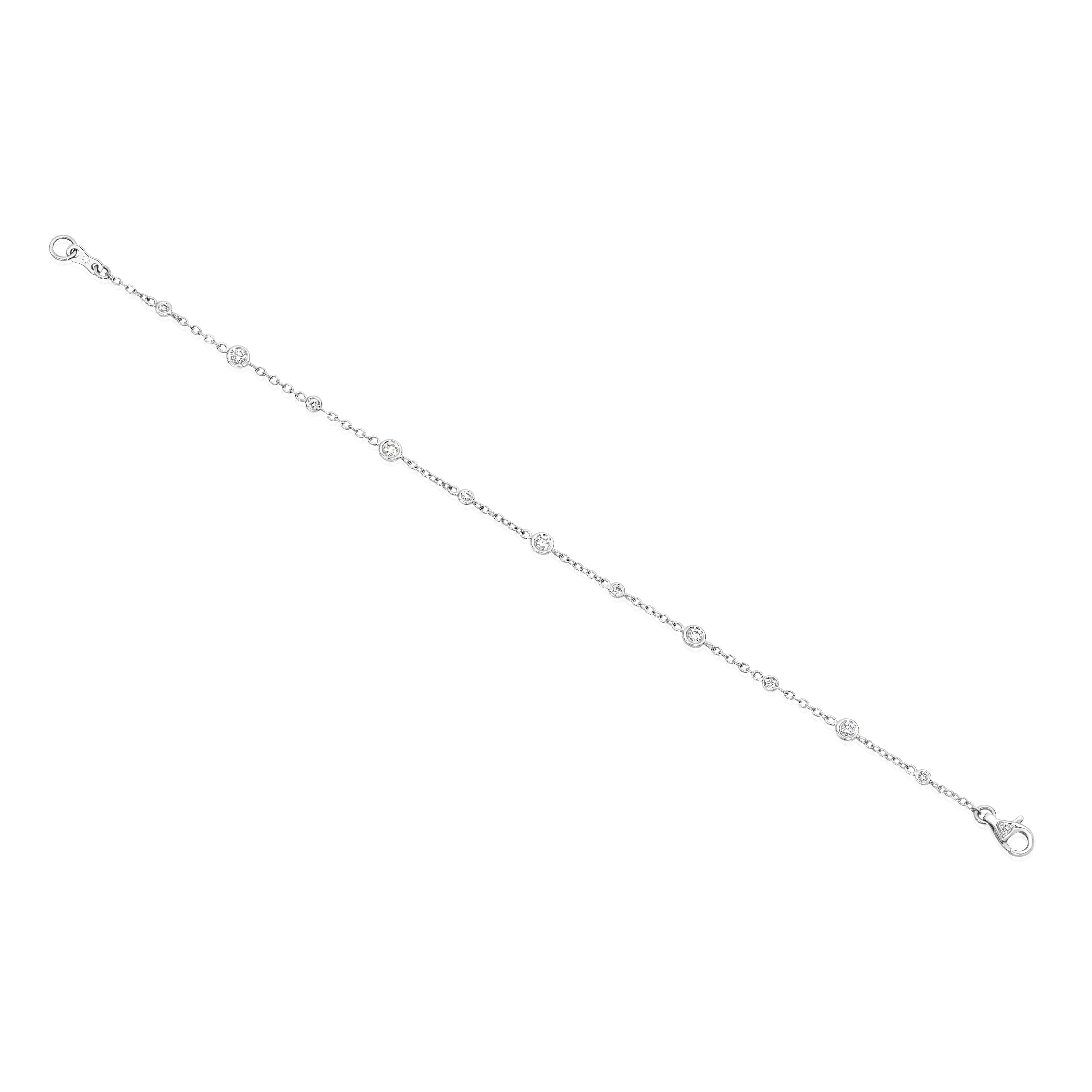 A stylish fashion bracelet, featuring round brilliant cut diamonds weighing 0.40 carat total, bezel-set in big and small alternating sizes. Lobster clasp is accented by a cluster of round cut melee diamonds. Finely made with 18K white gold, 7 inches