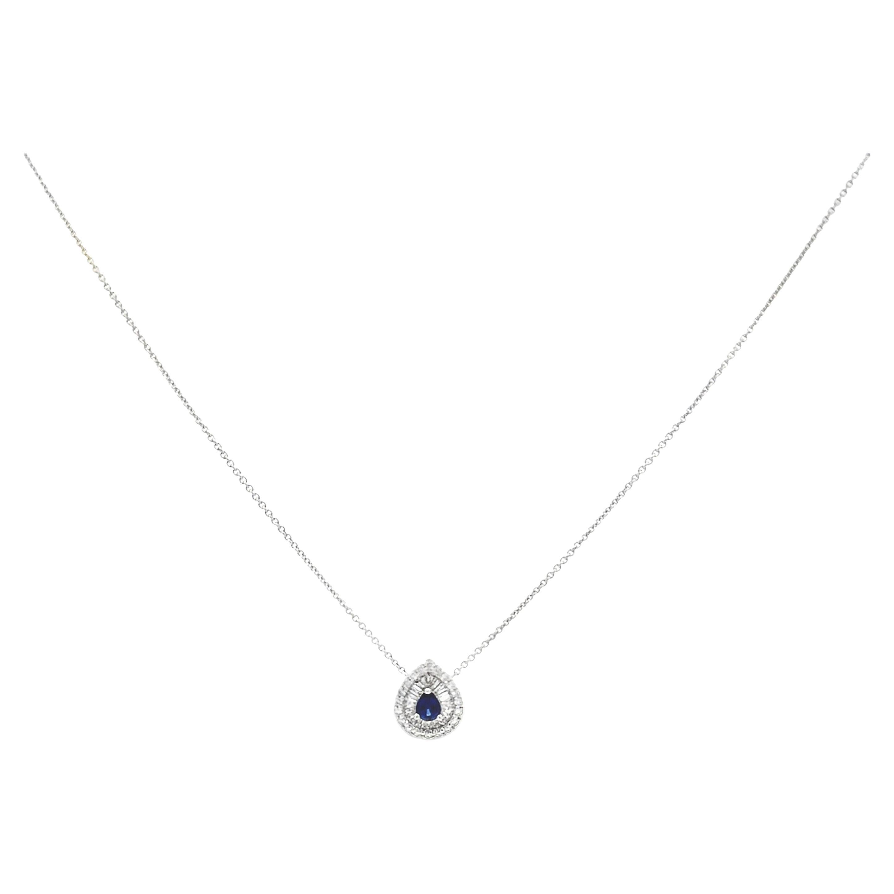 A fashionable pendant necklace, featuring a 0.42 carat pear shape sapphire, set on three rounded prongs. Accented by a double halo of baguette and round cut diamonds weighing 0.55 carat total. Finely made with 18K white gold. Perfect for casual