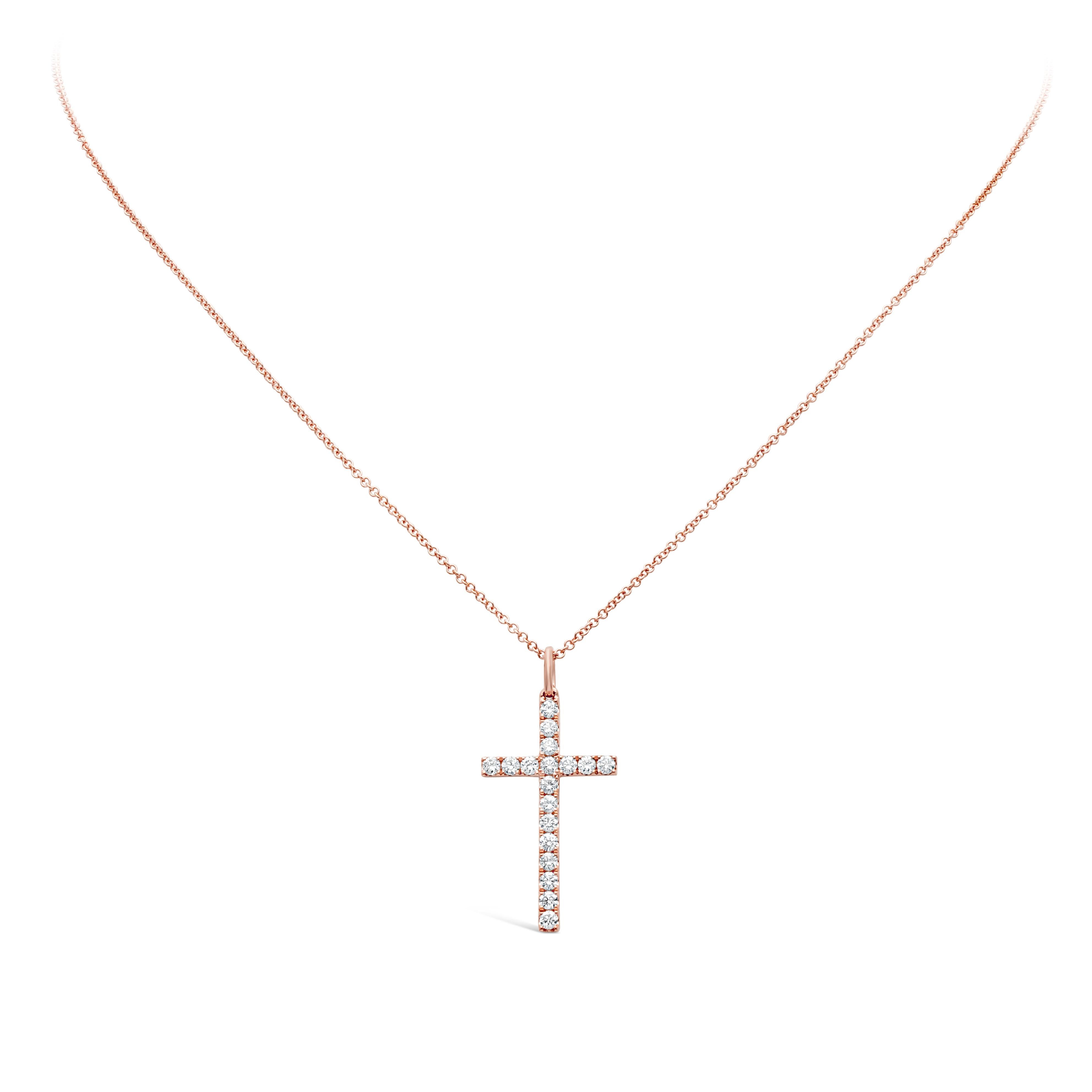 Ravissant collier pendentif mettant en valeur des diamants ronds de taille brillant pesant 0,44 carat au total, de couleur H et de pureté VS, sertis sur un motif de croix religieuse. Finement réalisé en or rose 18 carats. Suspendu à une chaîne en or
