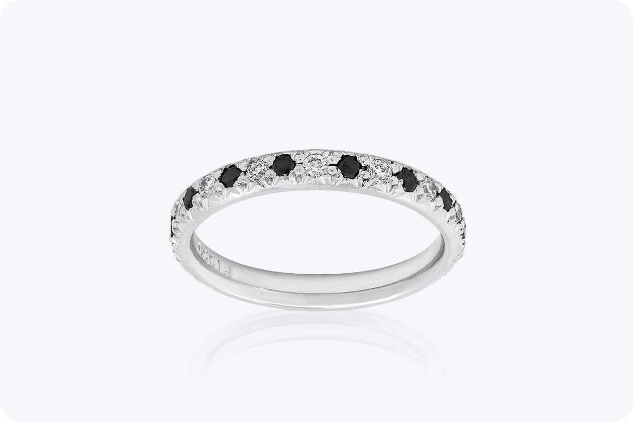 A versatile wedding band that can compliment any style and fashion. Showcases gorgeous black and white diamonds that alternates with each other in a french pave setting. Weight of the diamonds is 0.45 carats total. Made in platinum. Size 4 US and