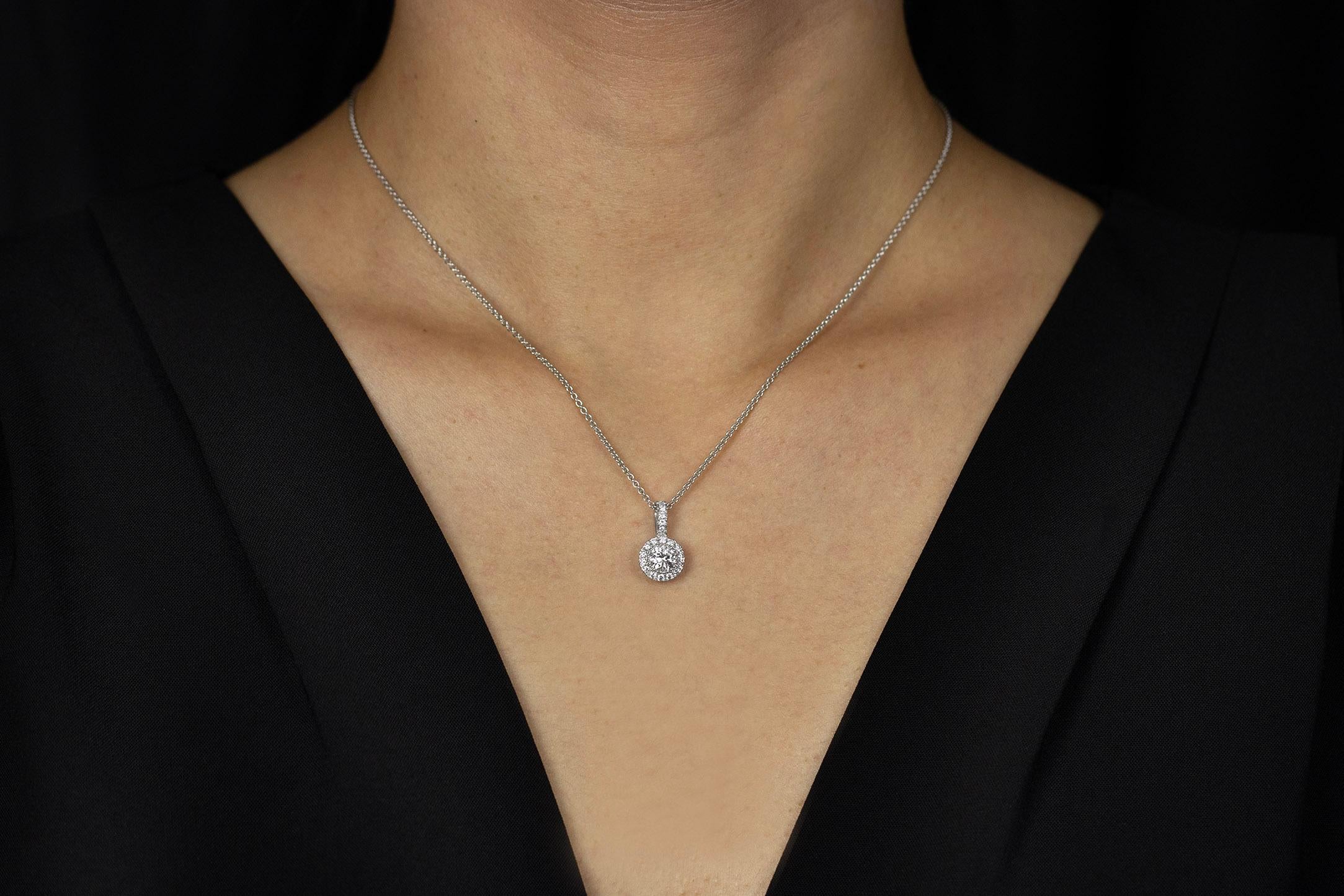 A simple pendant necklace that packs a lot of brilliance. Set with a 0.45 carats round diamond center set in a beaded bezel made with 14K white gold. The center diamond is surrounded by french pave-set diamonds for added radiance. Accent diamonds